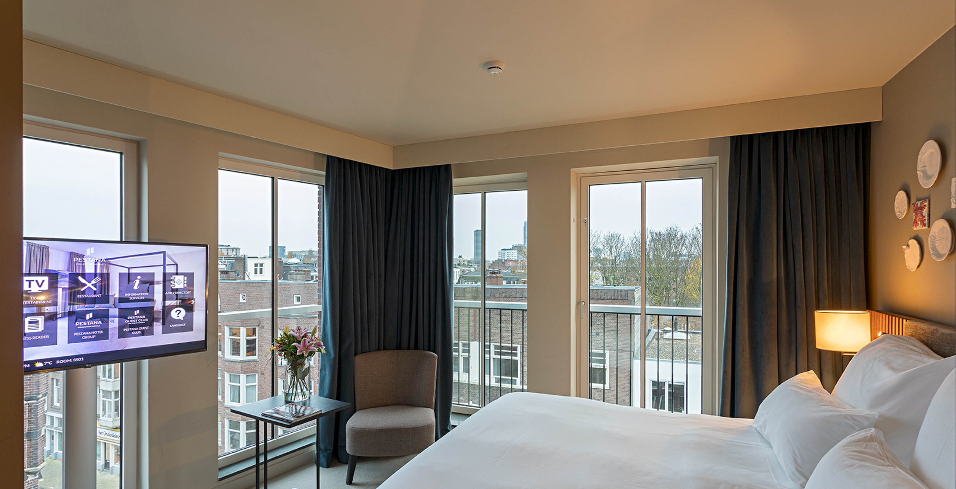 Studio room at Pestana Amsterdam Riverside has a double bed, a lamp and windows overlooking the street