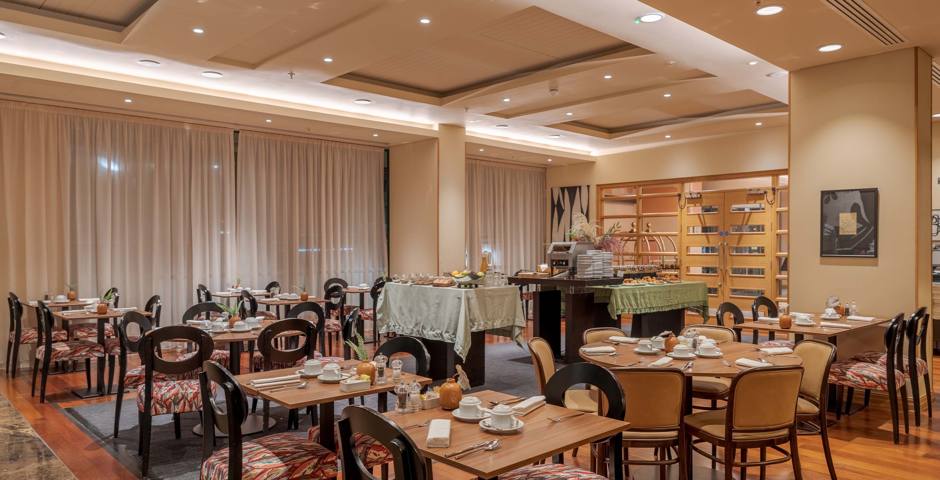 The Atlântico restaurant at the 4-Star Hotel in London has patterned chairs and white curtains