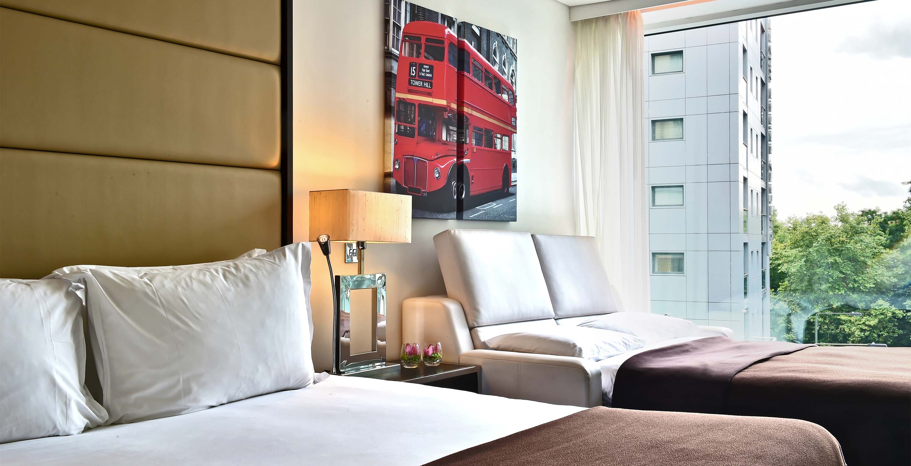 The Deluxe Superior Twin at Pestana Chelsea Bridge has a double bed, open sofa bed, London pictures, and a window with a view