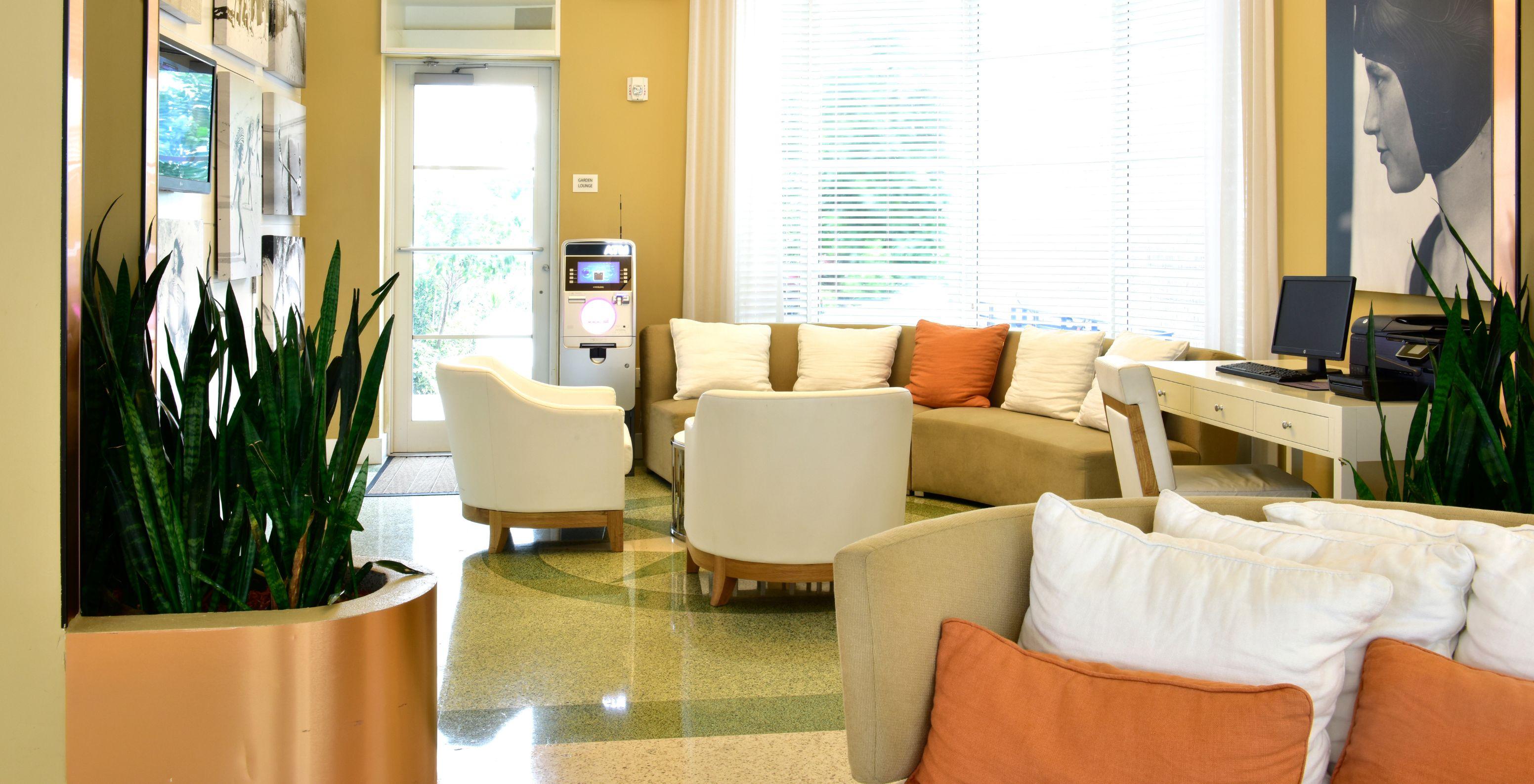 Lounge area with chairs, sofas, computer with photocopier, and ATM