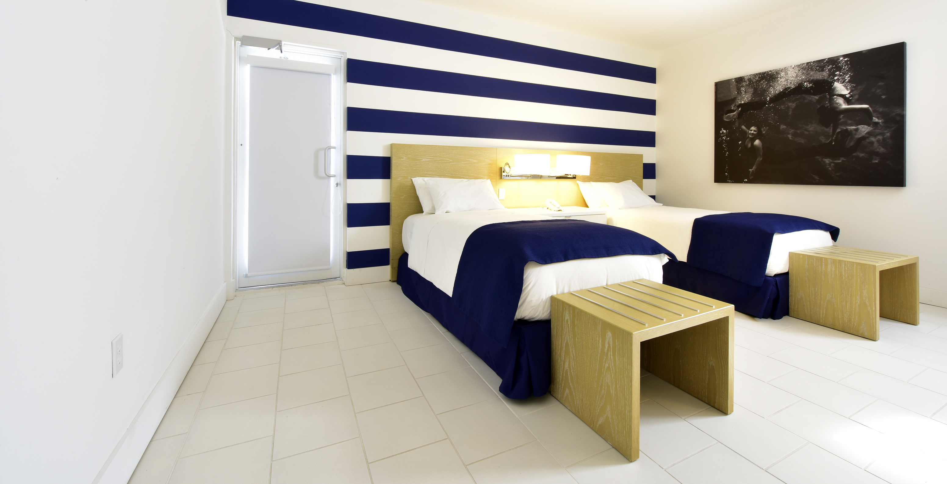 The Pestana Master Suite at Pestana Miami South Beach has two single beds and a lamp with bedside table