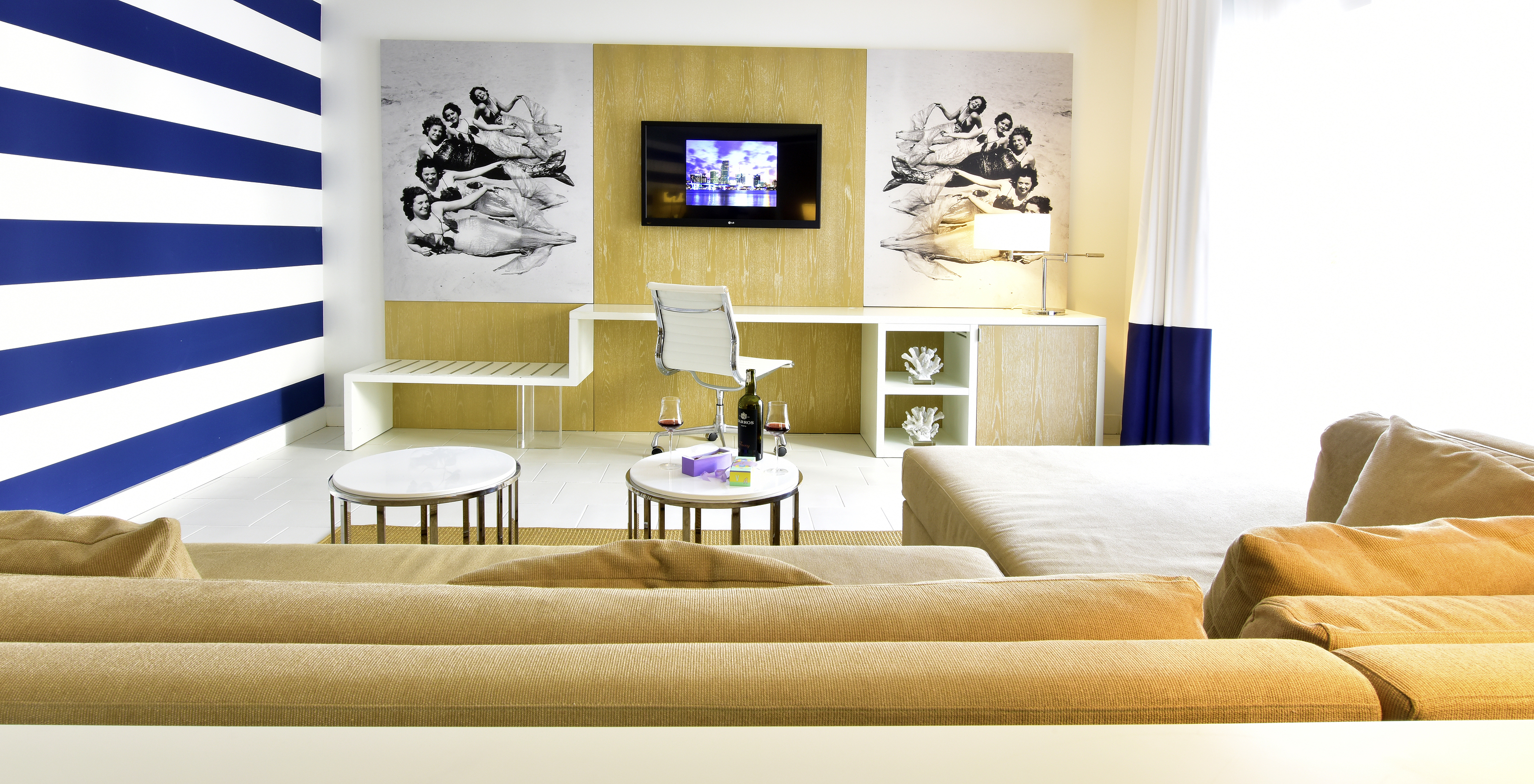 The Pestana Suite at Pestana Miami South Beach has a living room with a sofa with chaise longue, desk and TV