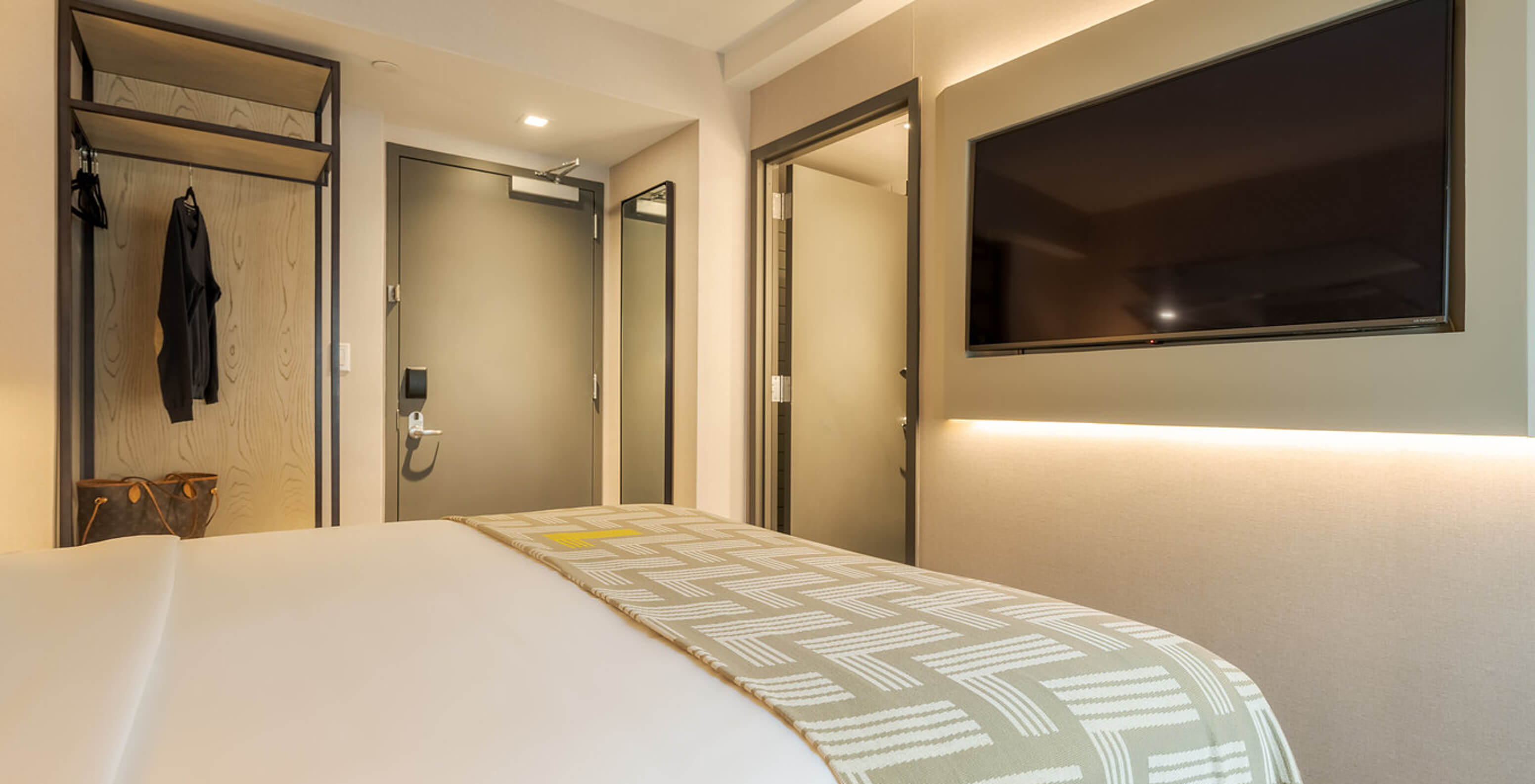 The Comfort ADA at Pestana CR7 Times Square has a double bed with a number seven quilt and a TV