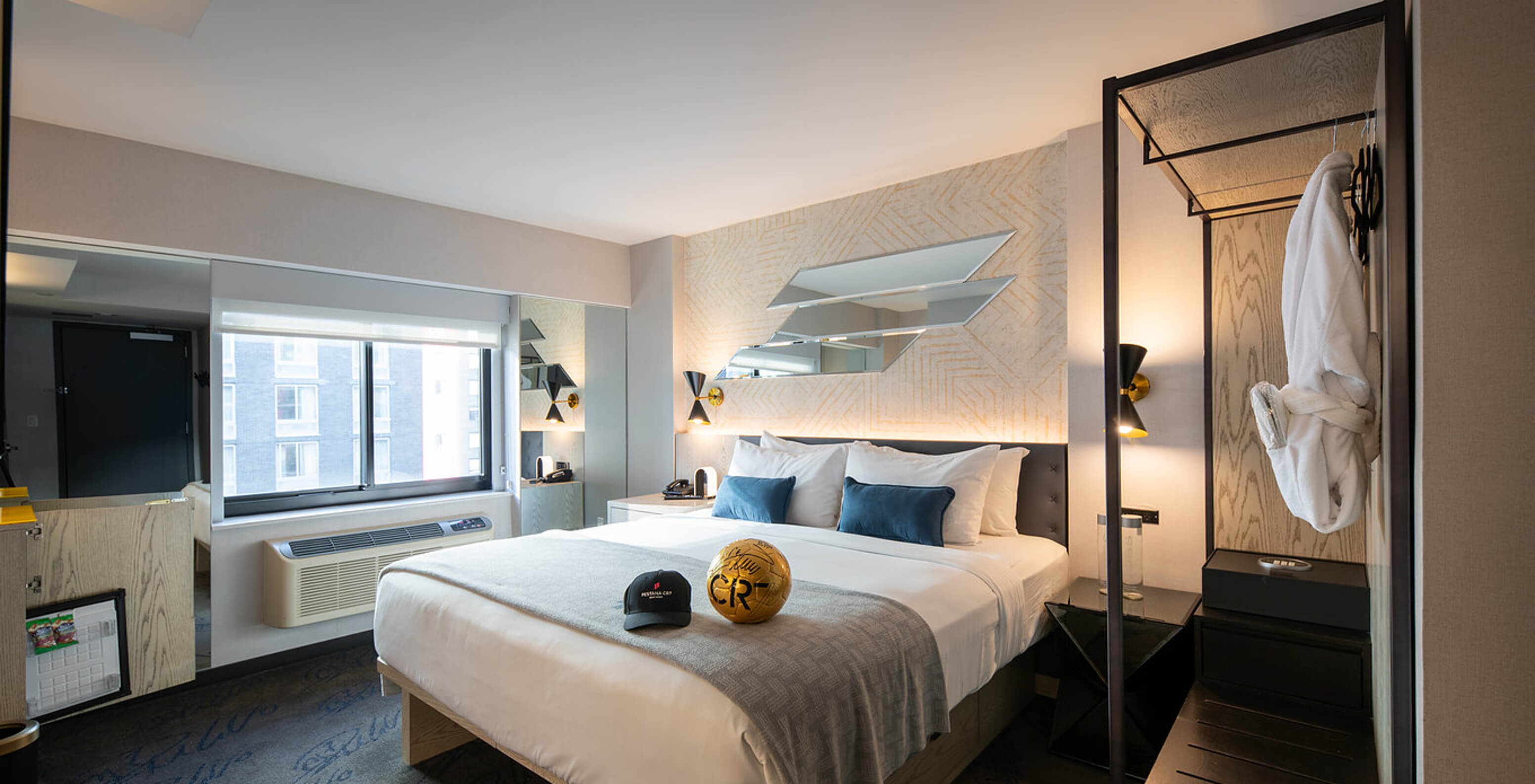 The Deluxe King Room ADA at Pestana CR7 Times Square has a double bed, window, and wardrobe