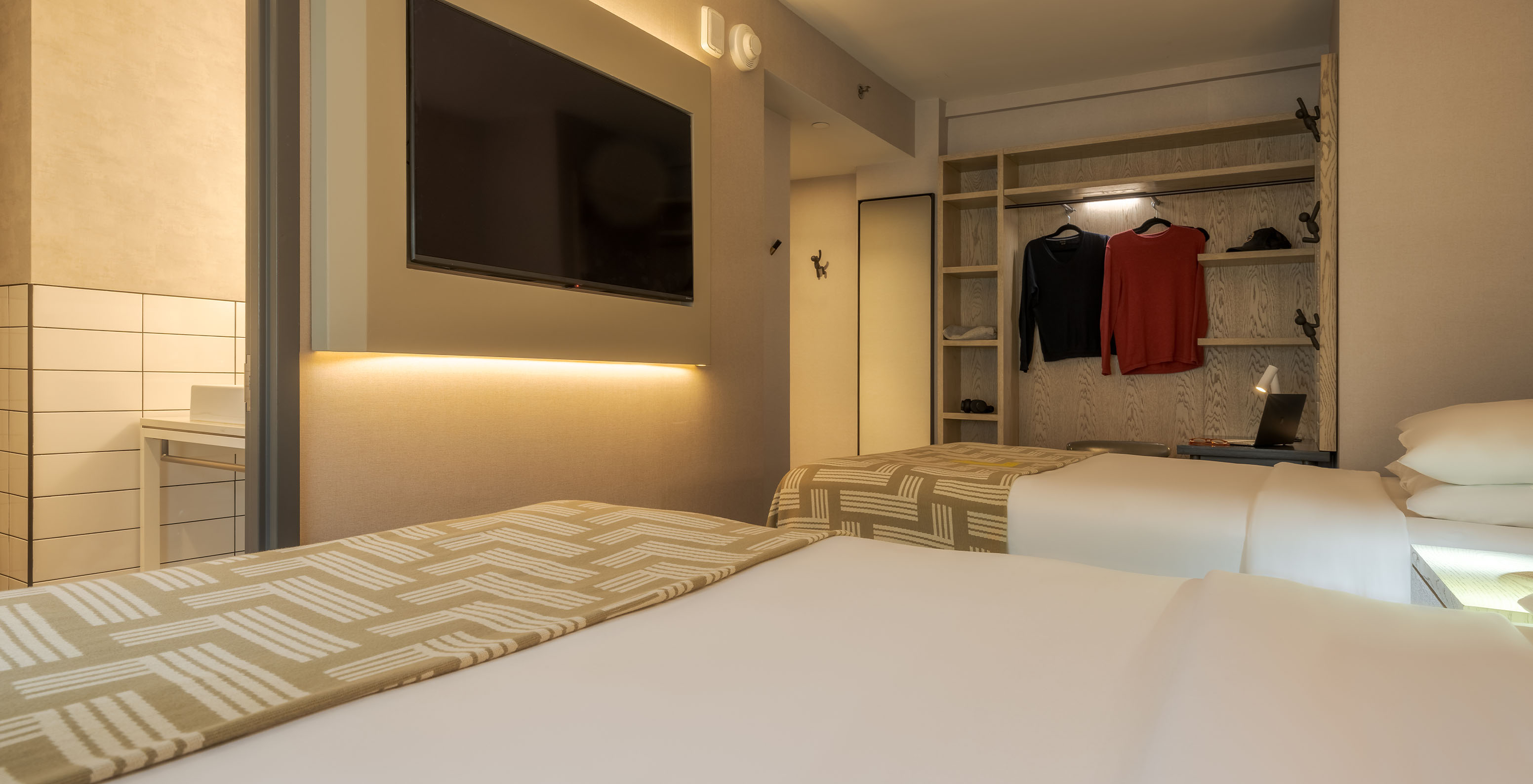 The Superior Double at Pestana CR7 Times Square has two beds with a bedspread with the number seven, a TV, and a wardrobe