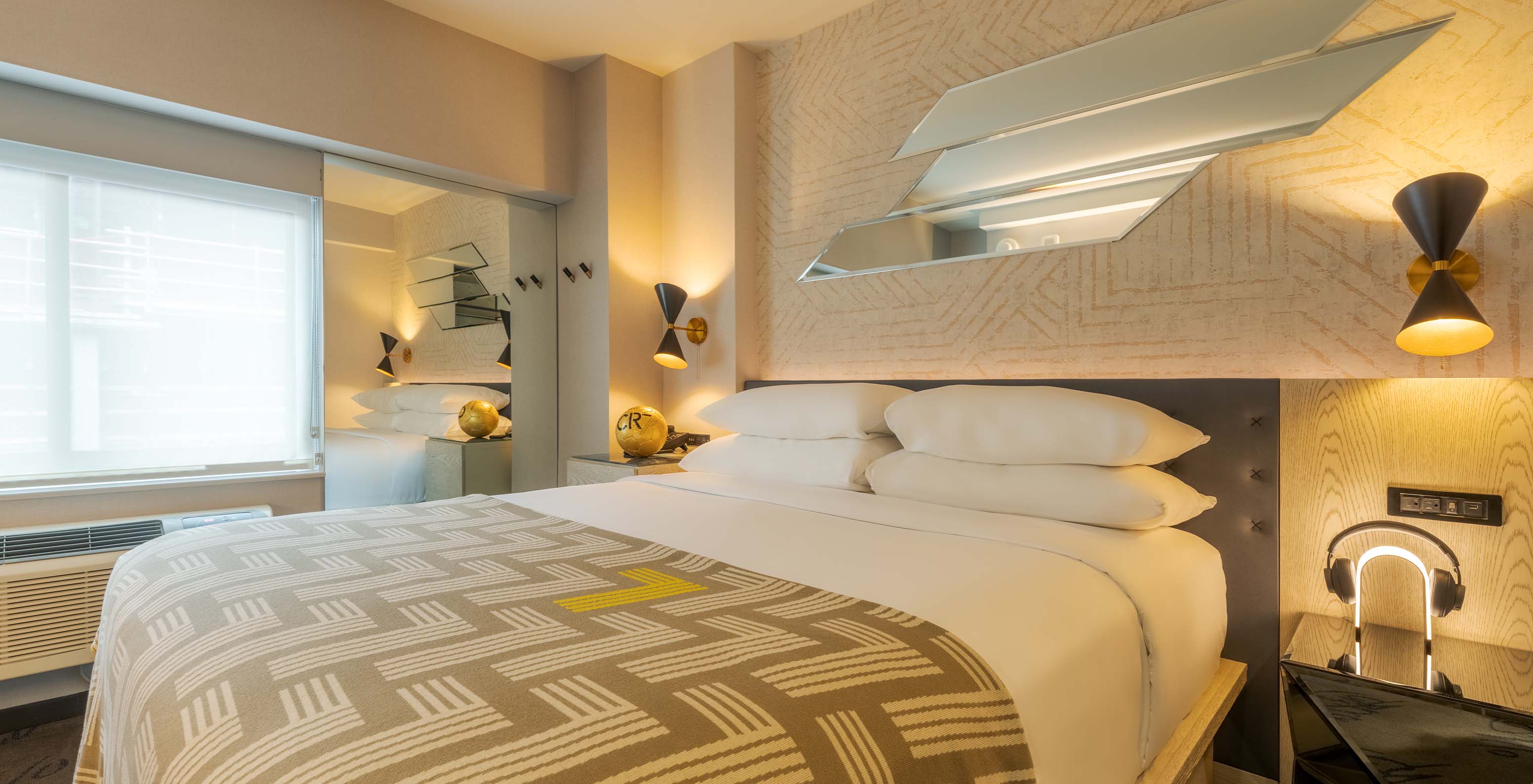 The Superior King at Pestana CR7 Times Square has a double bed with a bedspread with the number seven and a window