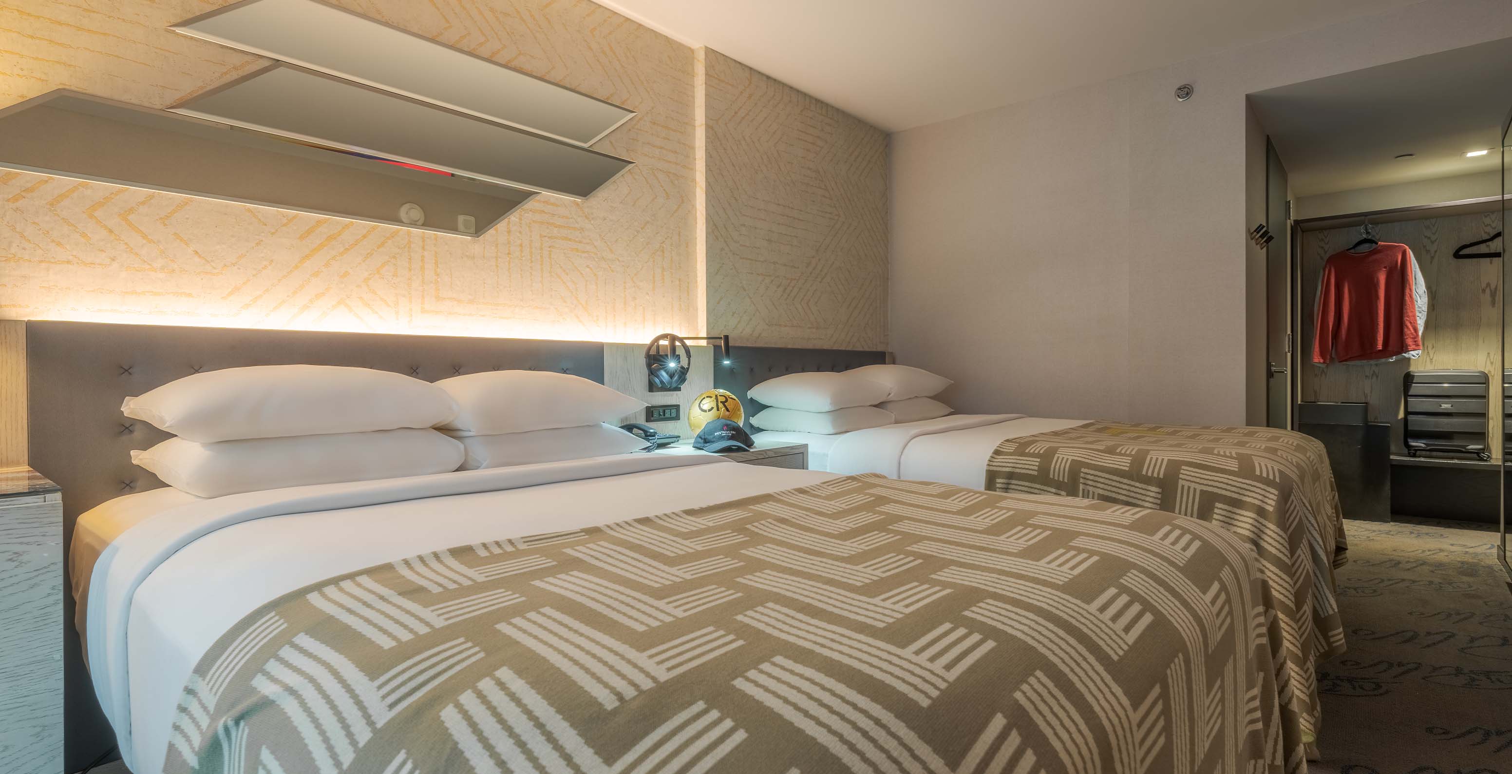 The Comfort Double ADA at Pestana CR7 Times Square has two beds with a bedspread with the number seven and a wardrobe