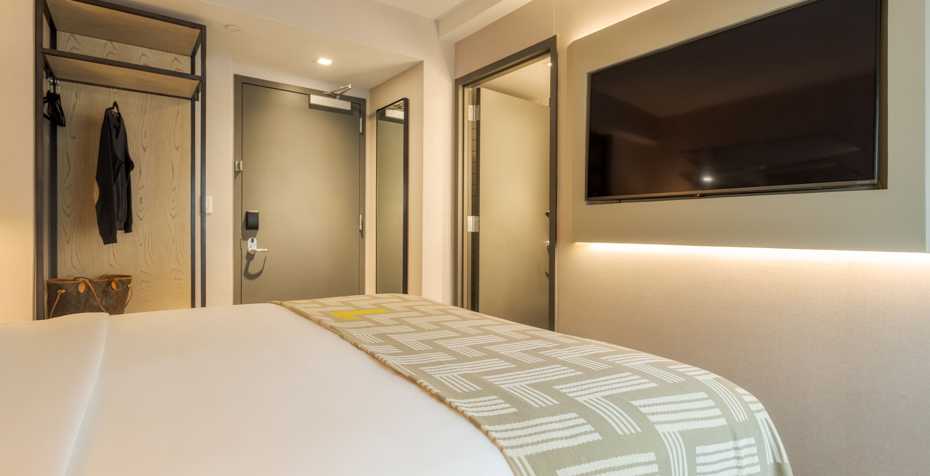 The Deluxe King at Pestana CR7 Times Square has a double bed with a bedspread with the number seven, and a TV