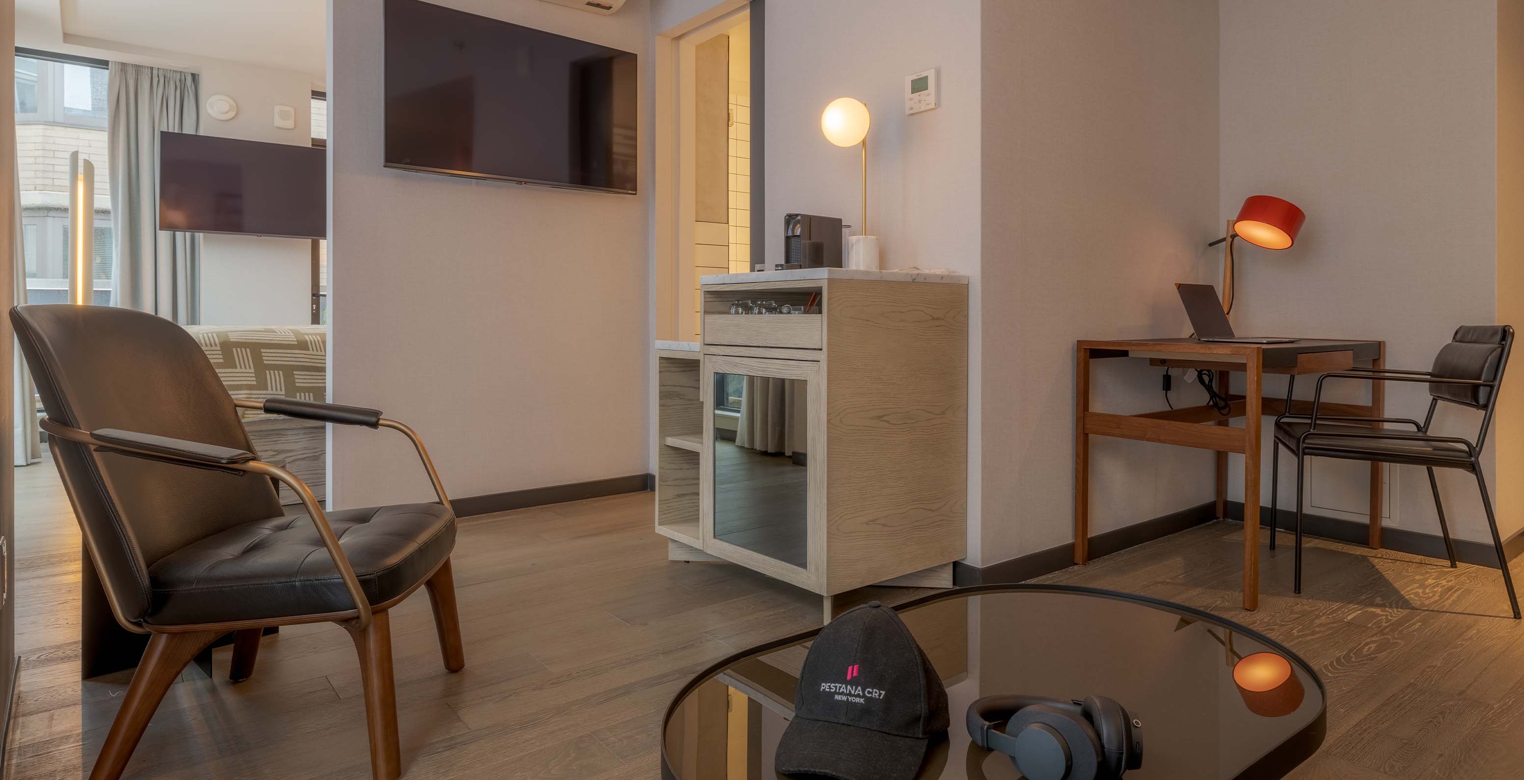 The Junior Suite with Balcony and View at Pestana CR7 Times Square has a desk, an armchair, and a coffee machine