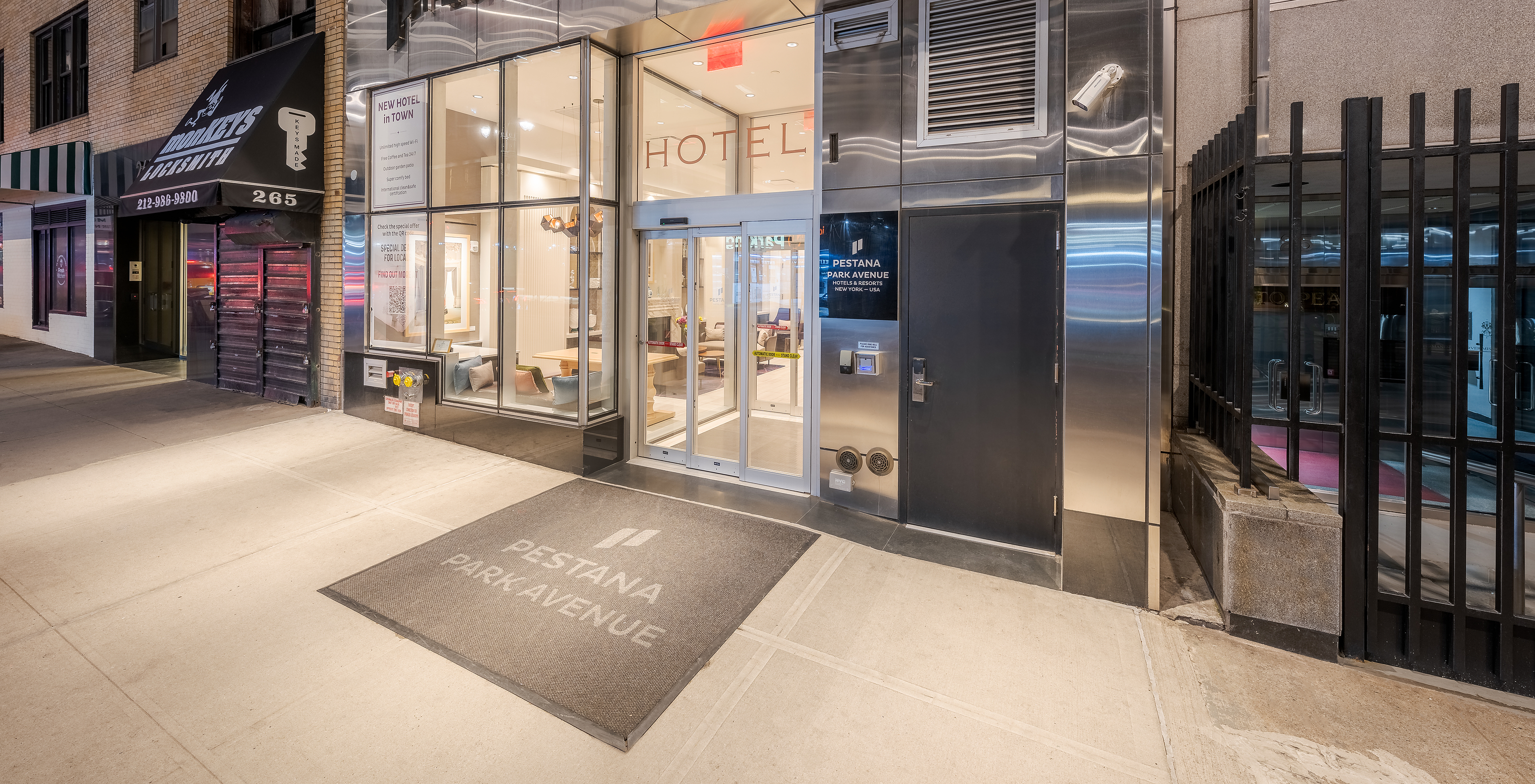 Facade of Pestana Park Avenue, with illuminated entrance, automatic glass doors and hotel name in highlight