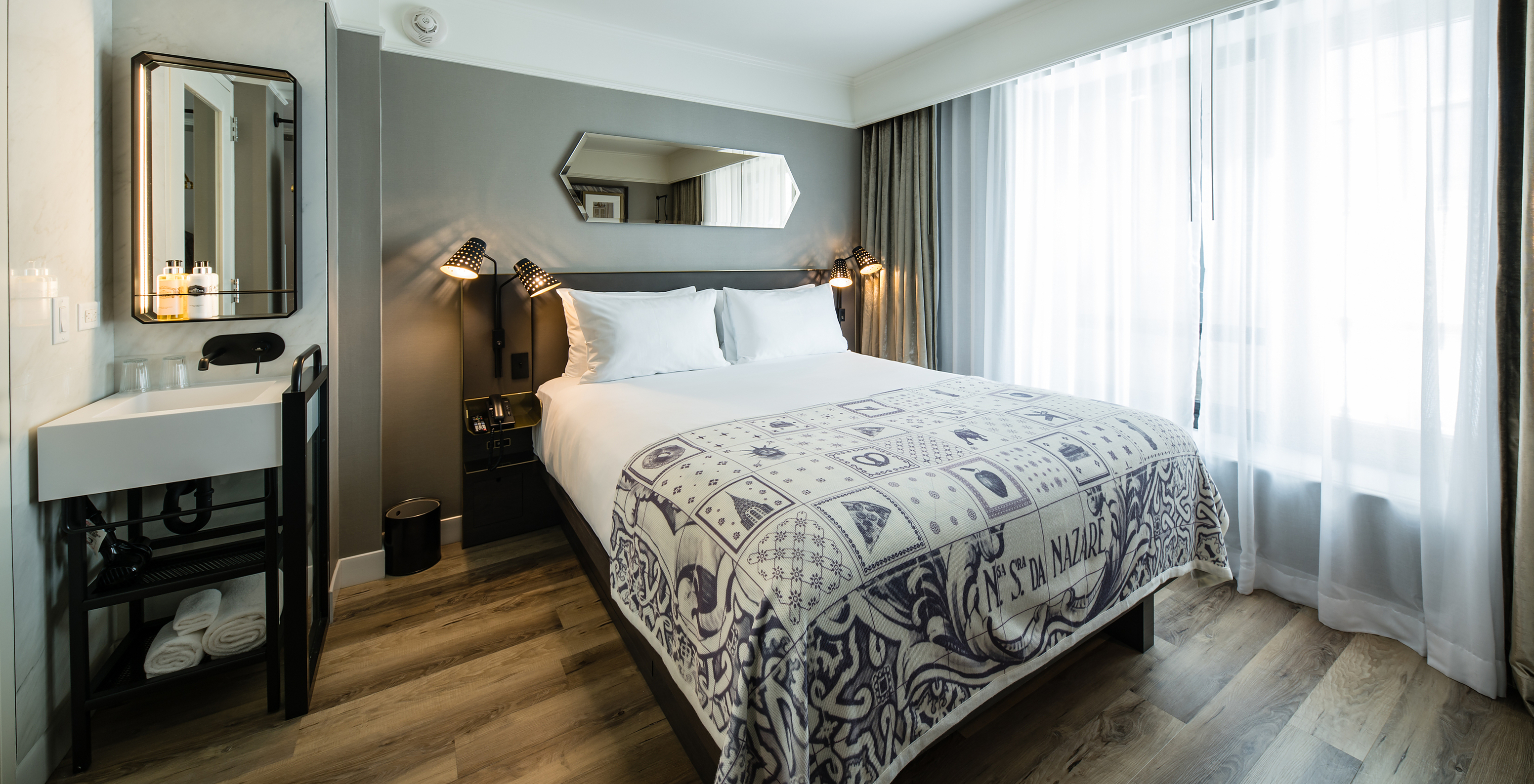 The Superior room at Pestana Park Avenue has a double bed, with a sink and mirror in the room and a bedside table