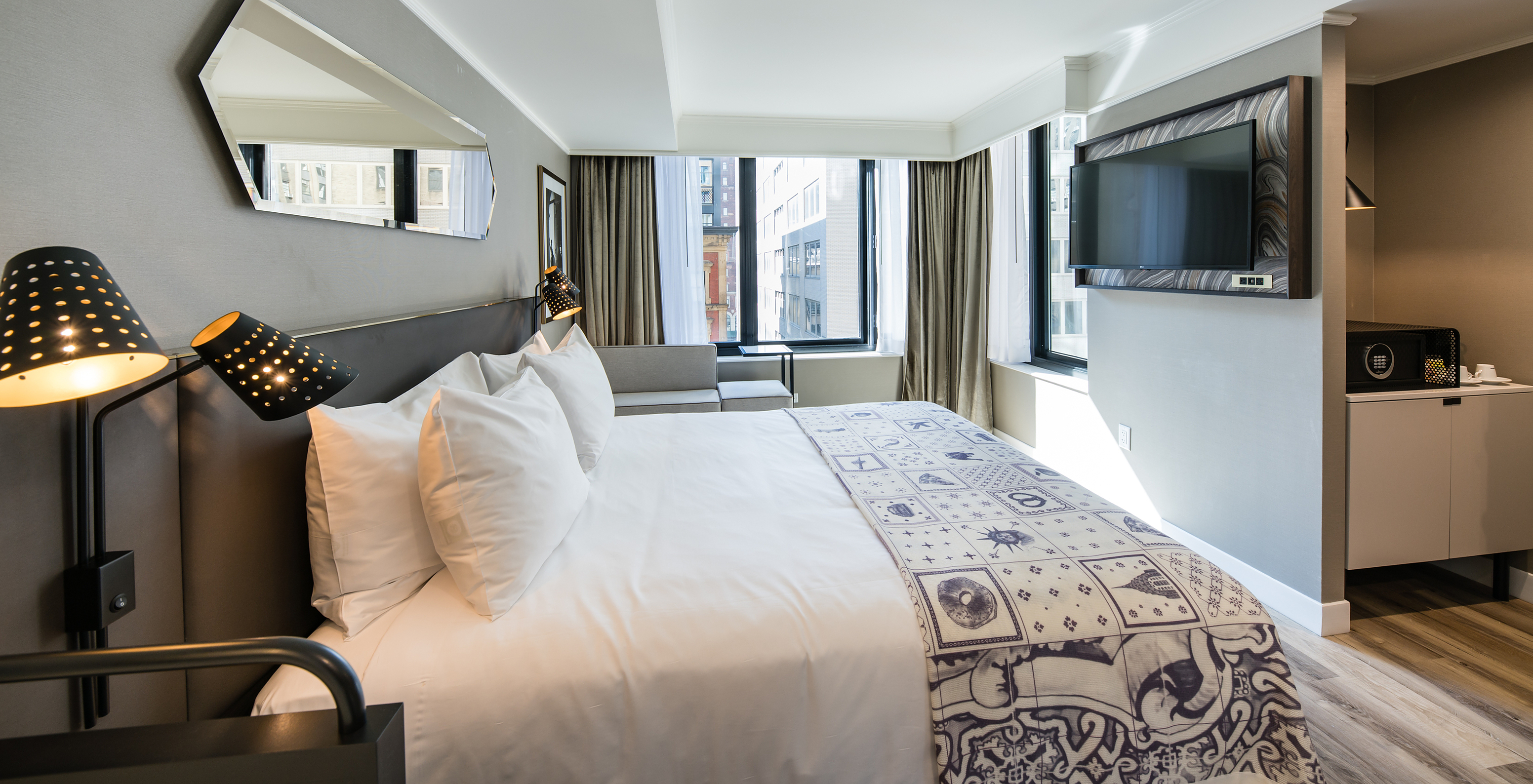 The Superior room at Pestana Park Avenue has a double bed, with TV, mirror and view of the city