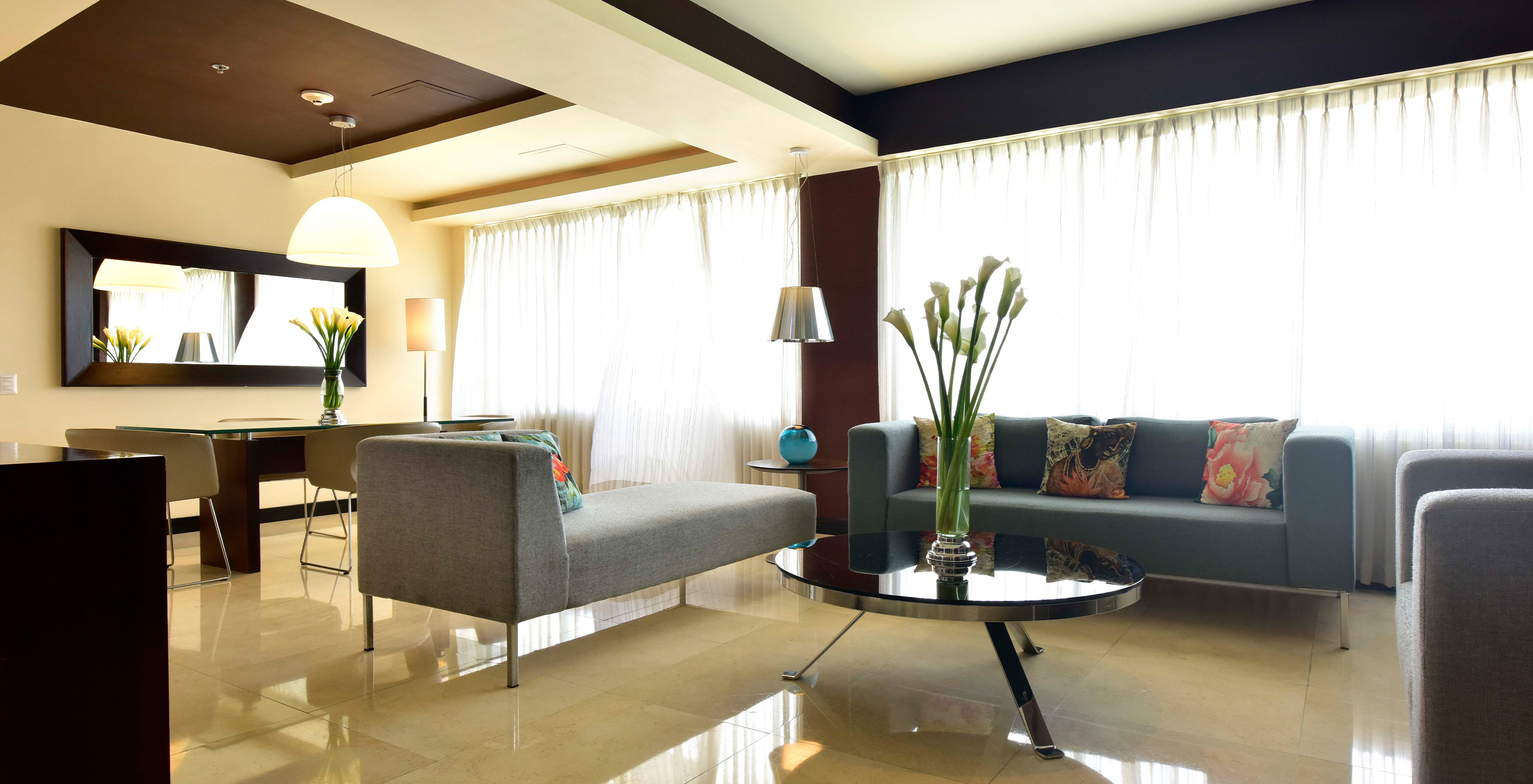 The Presidential Suite at Pestana Caracas has a spacious living room with three comfortable sofas and a dining table