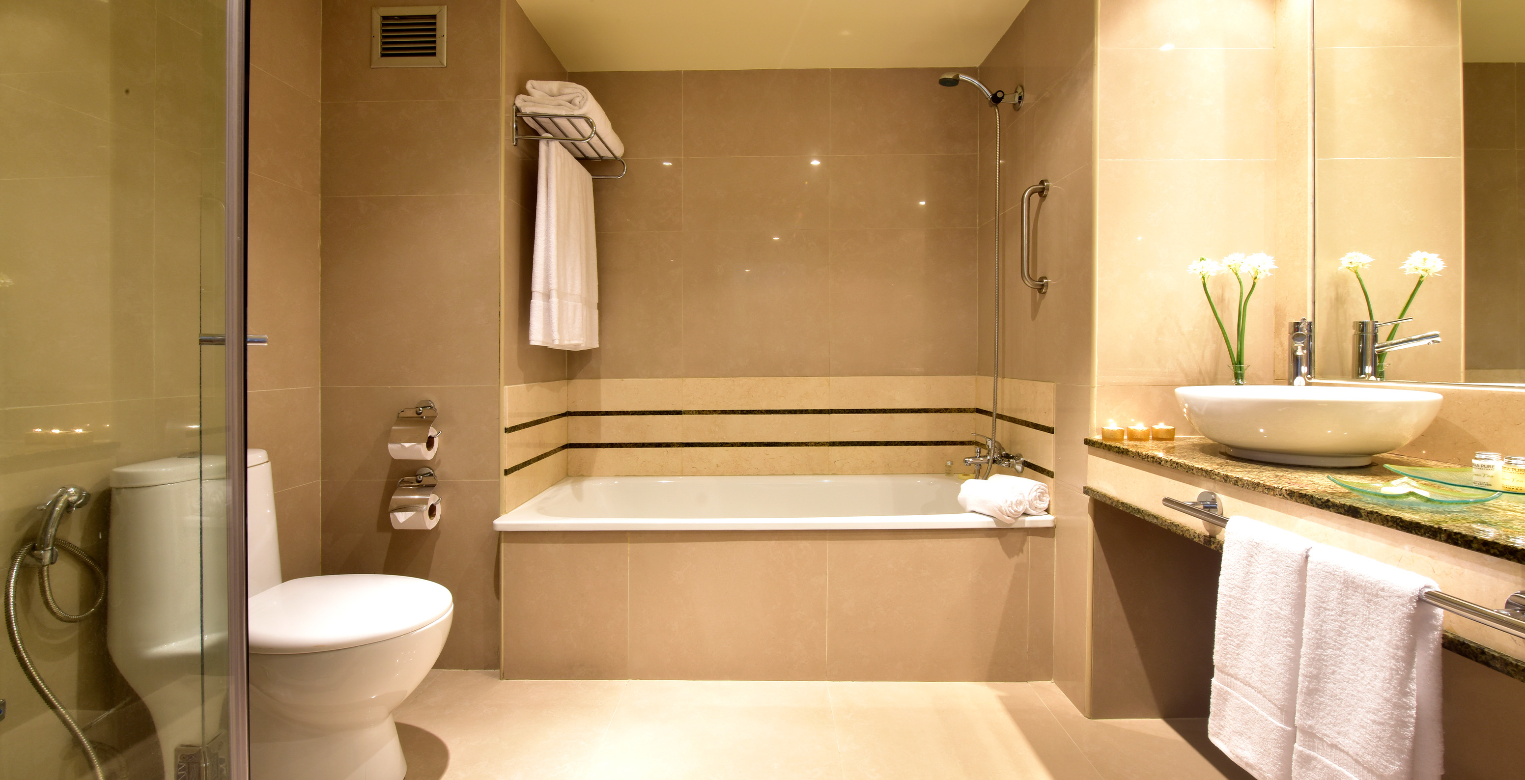 The Twin Superior Room at Pestana Caracas has a spacious bathroom with a bathtub, sink with mirror, and toilet