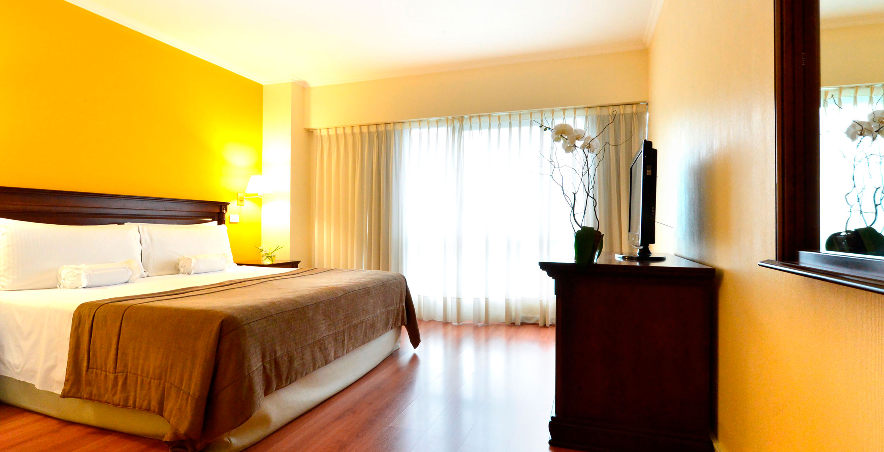 The Queen Superior Room at Pestana Buenos Aires has a double bed, a TV, a mirror, and a bedside table with a lamp