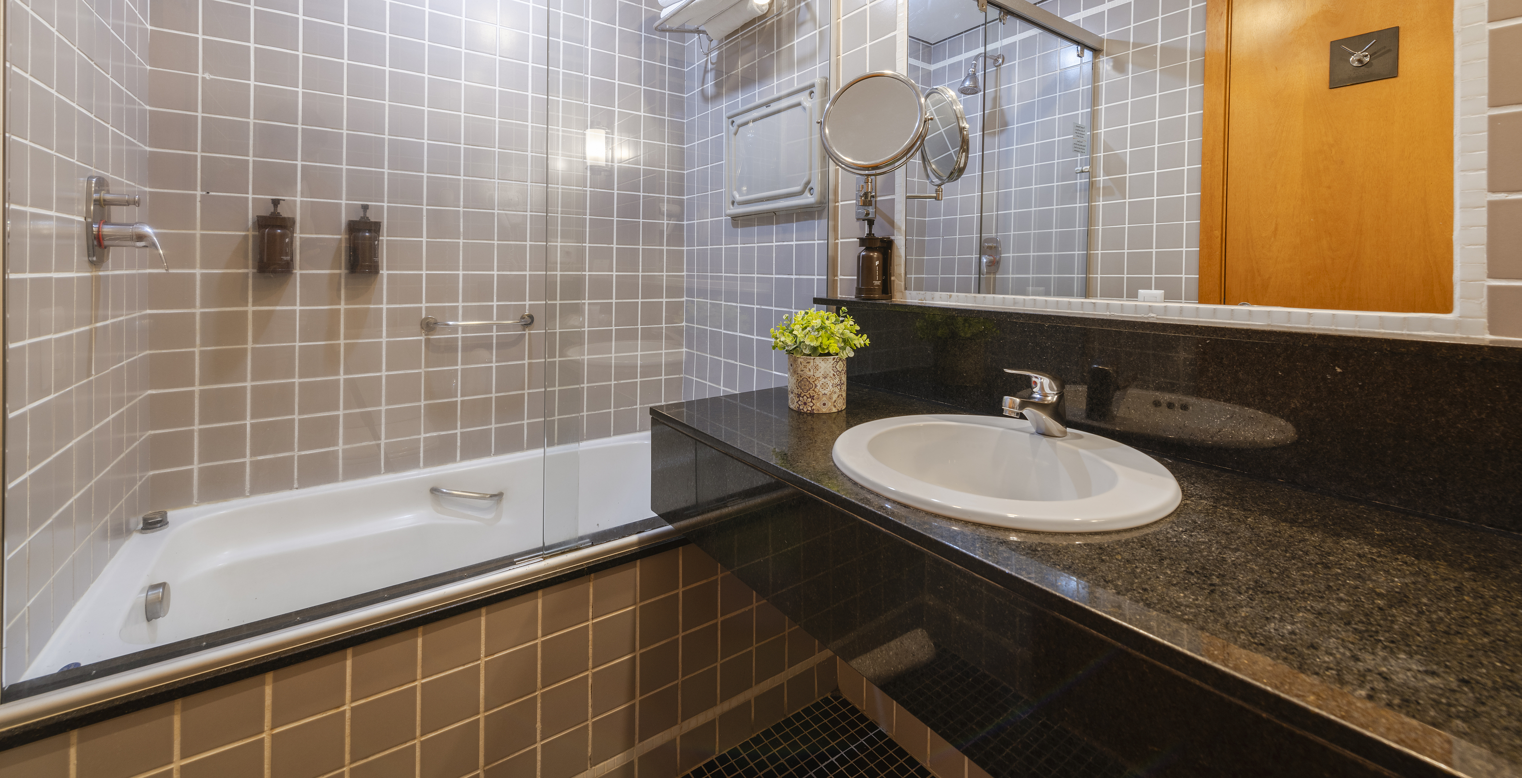 The Twin Superior at Pestana Curitiba has a bathroom with a bathtub in gray tiles and a countertop with a sink