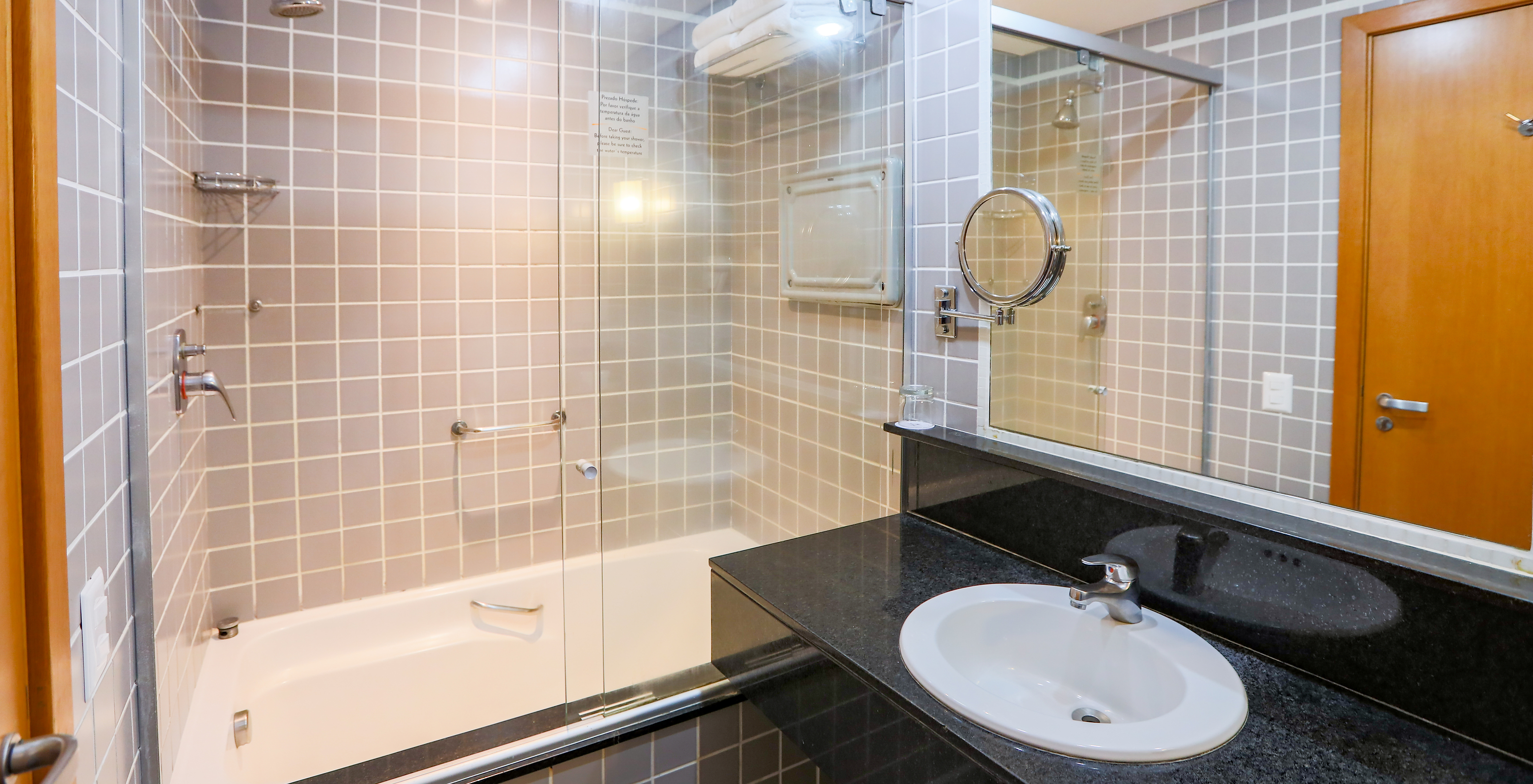 The Family Room at Pestana Curitiba has a bathroom with a bathtub and a black countertop with a sink