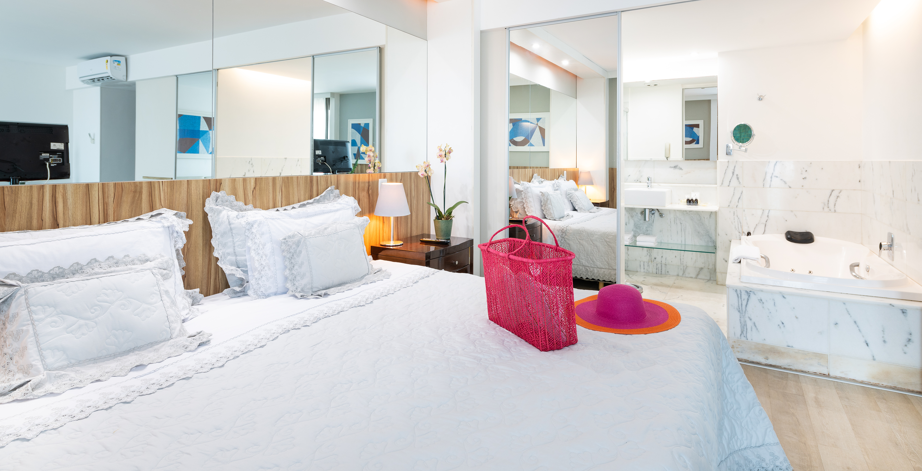 The Junior Suite of Pestana Rio Atlântica has a double bed, a mirror, and a bathroom with a bathtub