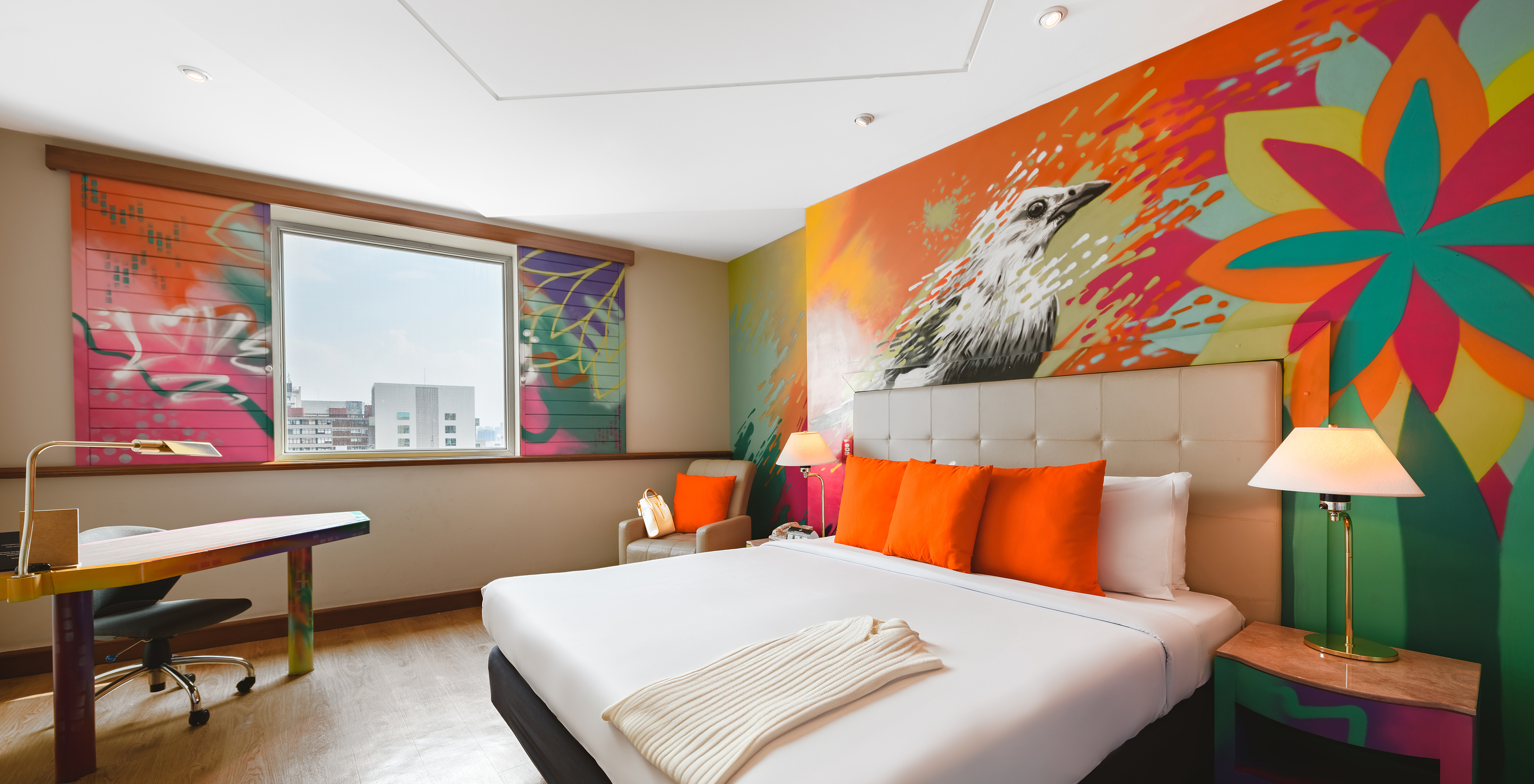 The Art Room of Pestana São Paulo has a double bed and colorful paintings on the wall by the artists Alma Salgada