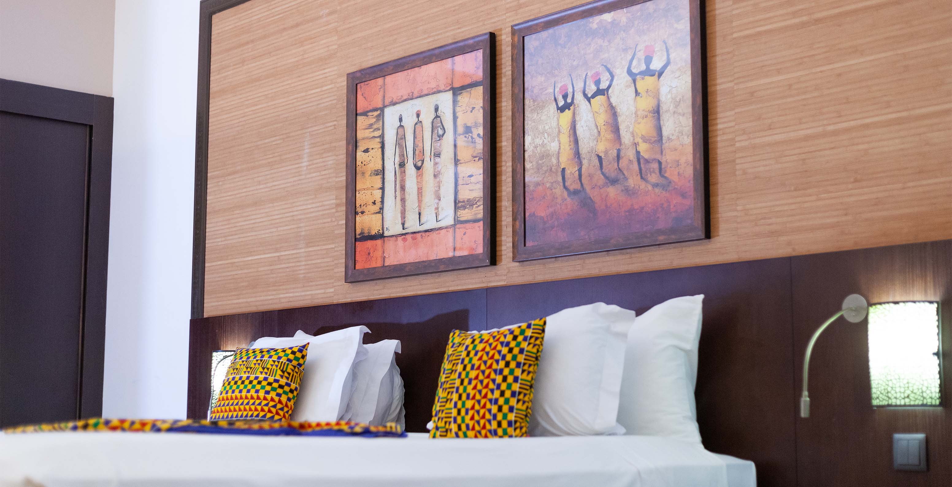 The Premium room at Pestana Tropico features two art pieces above the double bed and a bedside table