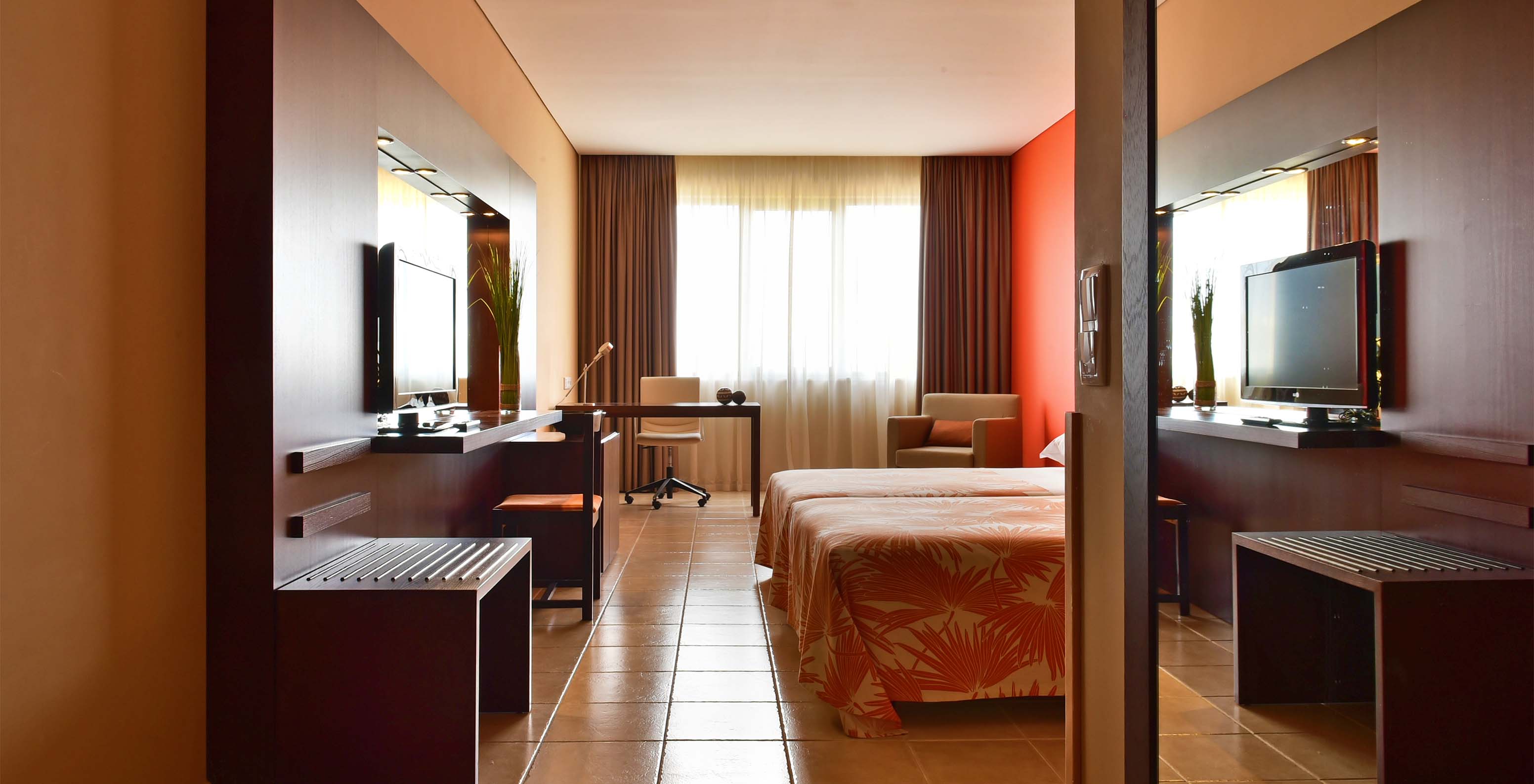 The Suite at Pestana Tropico features two single beds, desk, television, and an armchair