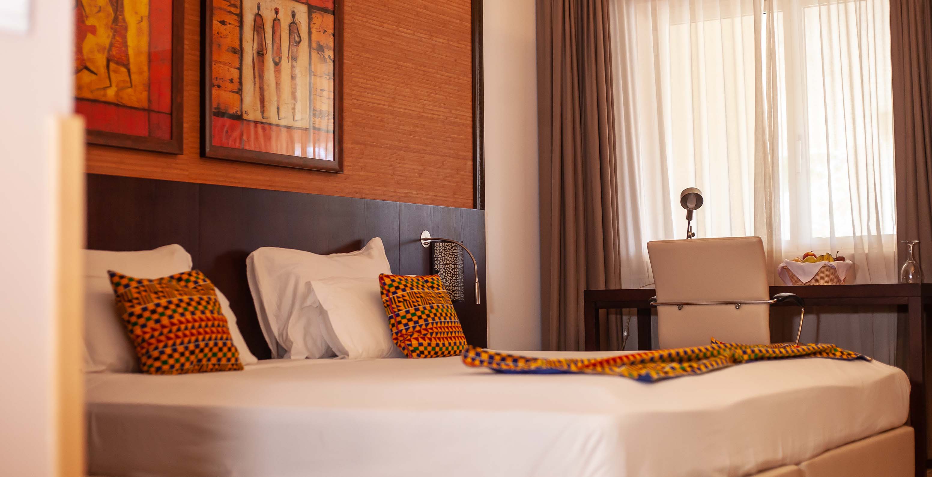 The Premium room at Pestana Tropico features a double bed, desk, and artistic walls