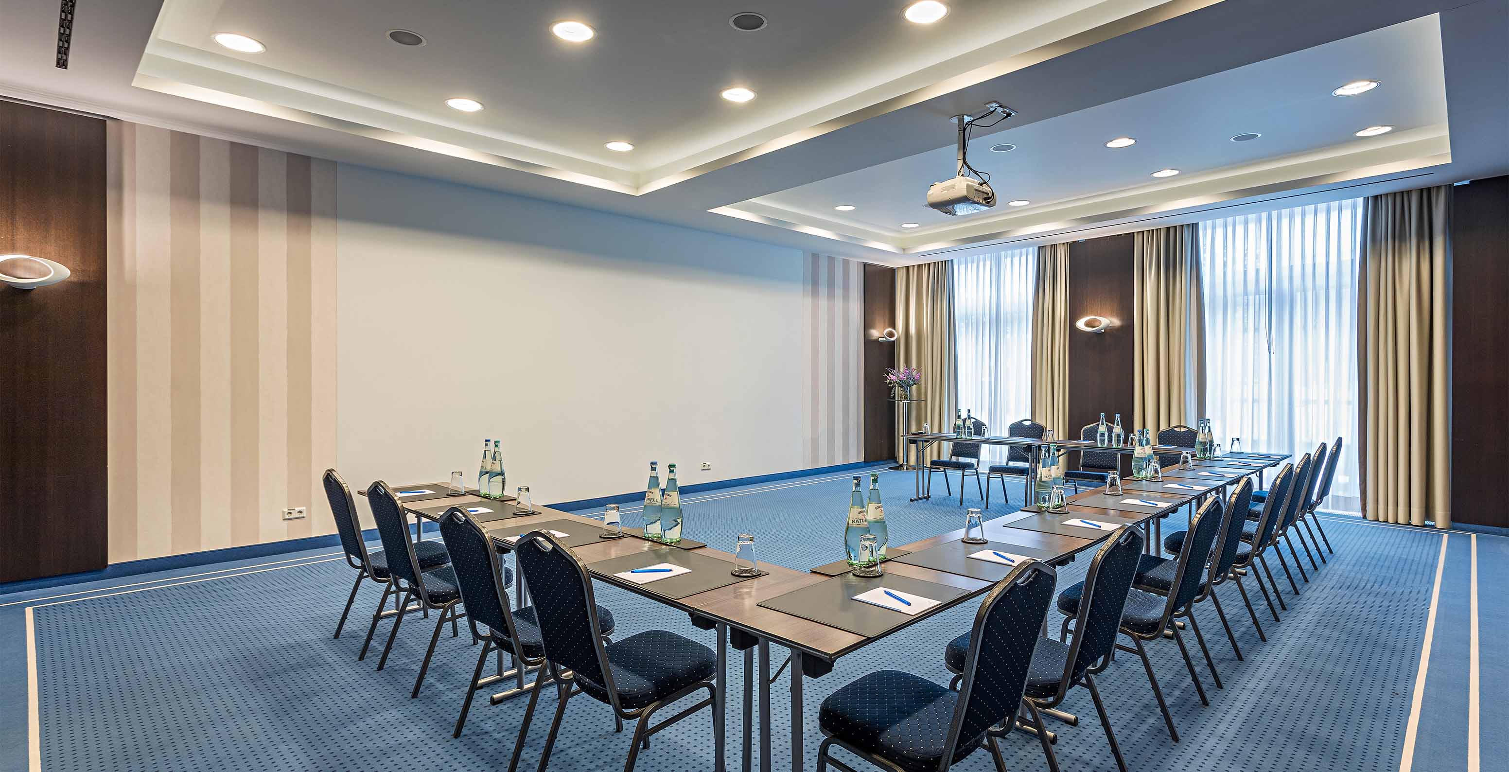 Pestana Berlin, a central hotel in Berlin next to Tiergarten, includes a meeting room with chairs, tables, and projector