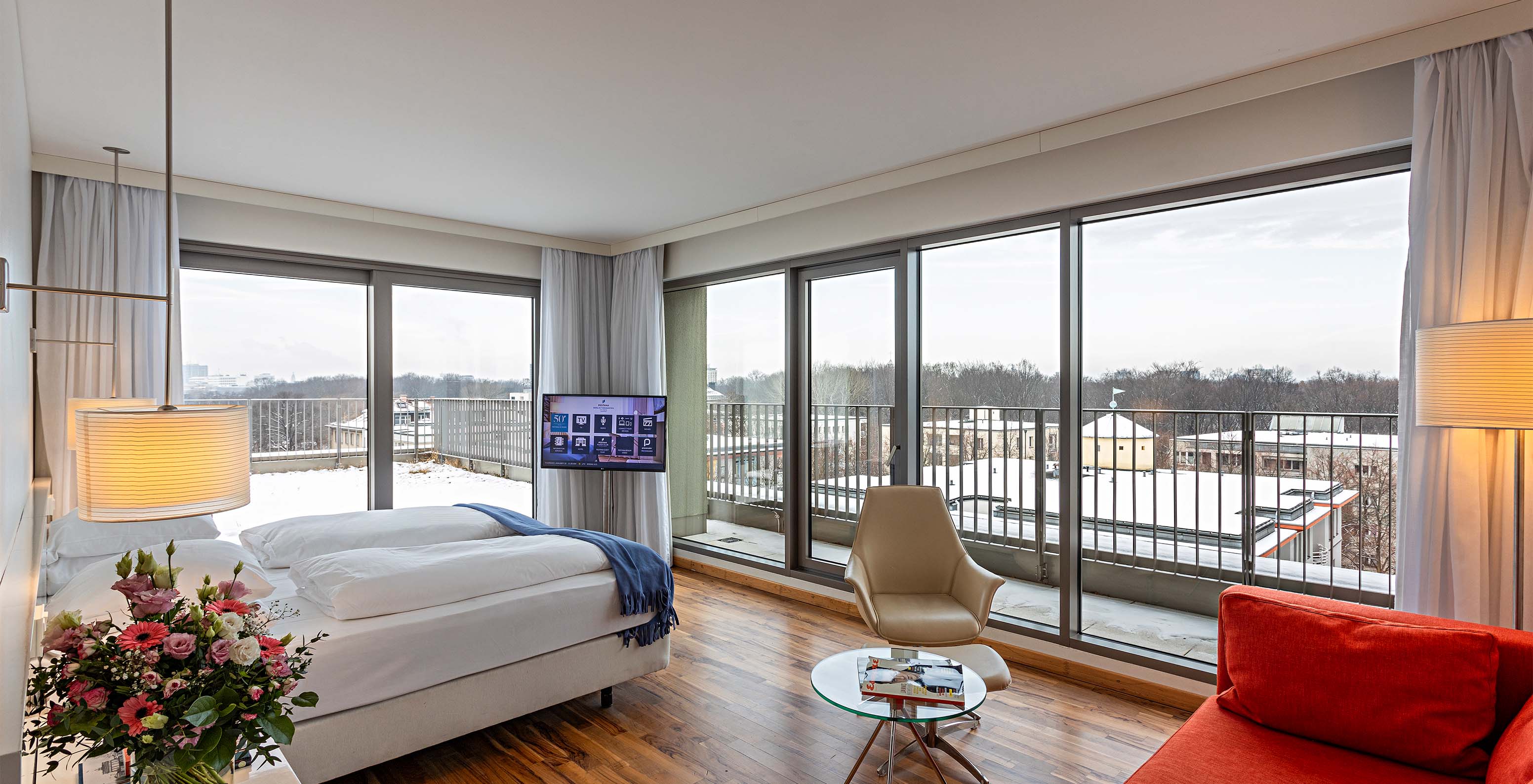 Family Deluxe room at Pestana Berlin Tiergarten has a double bed, TV, a sofa and an armchair