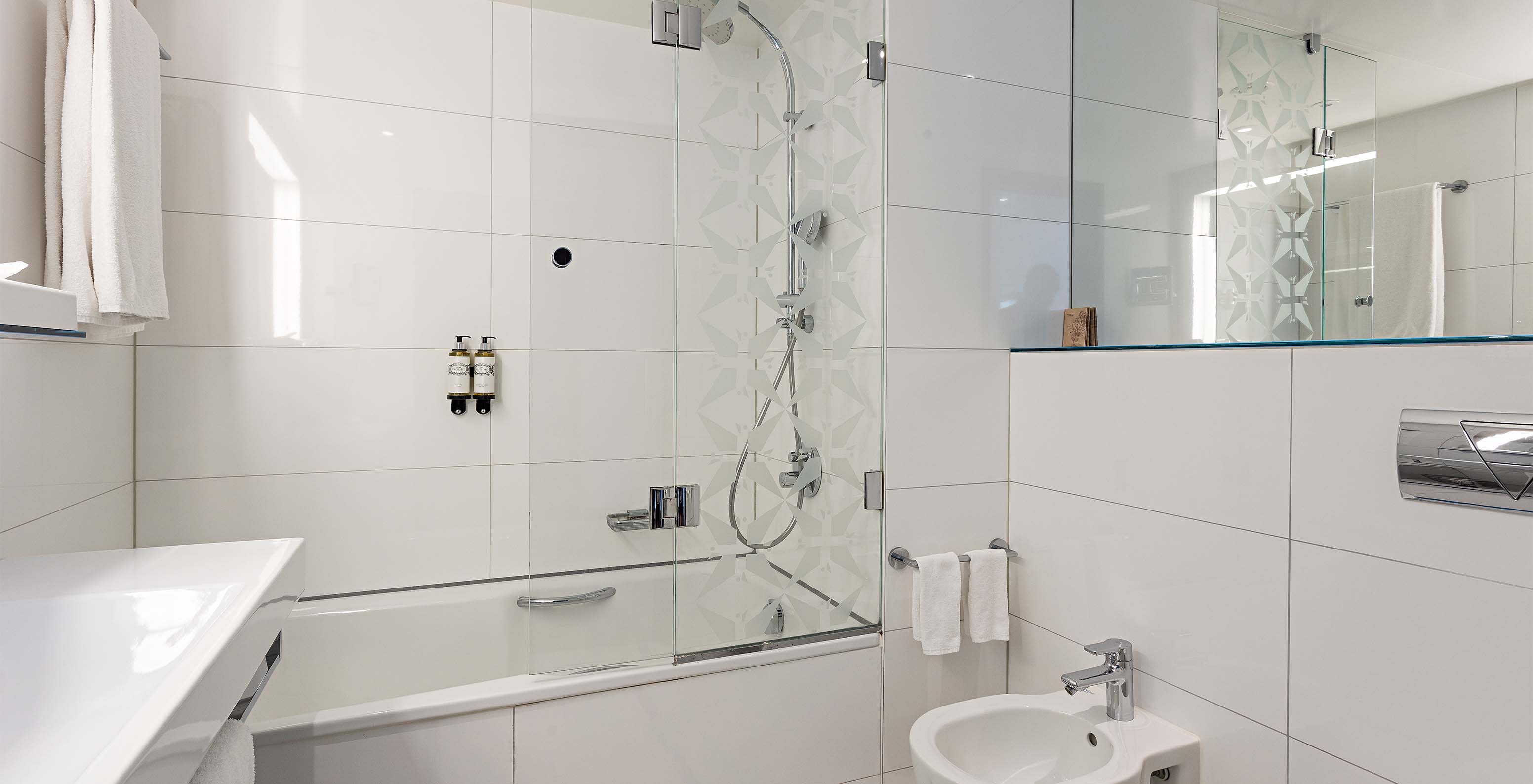 Large Family Deluxe room at Pestana Berlin Tiergarten has a bathroom with bathtub and shower and a sink