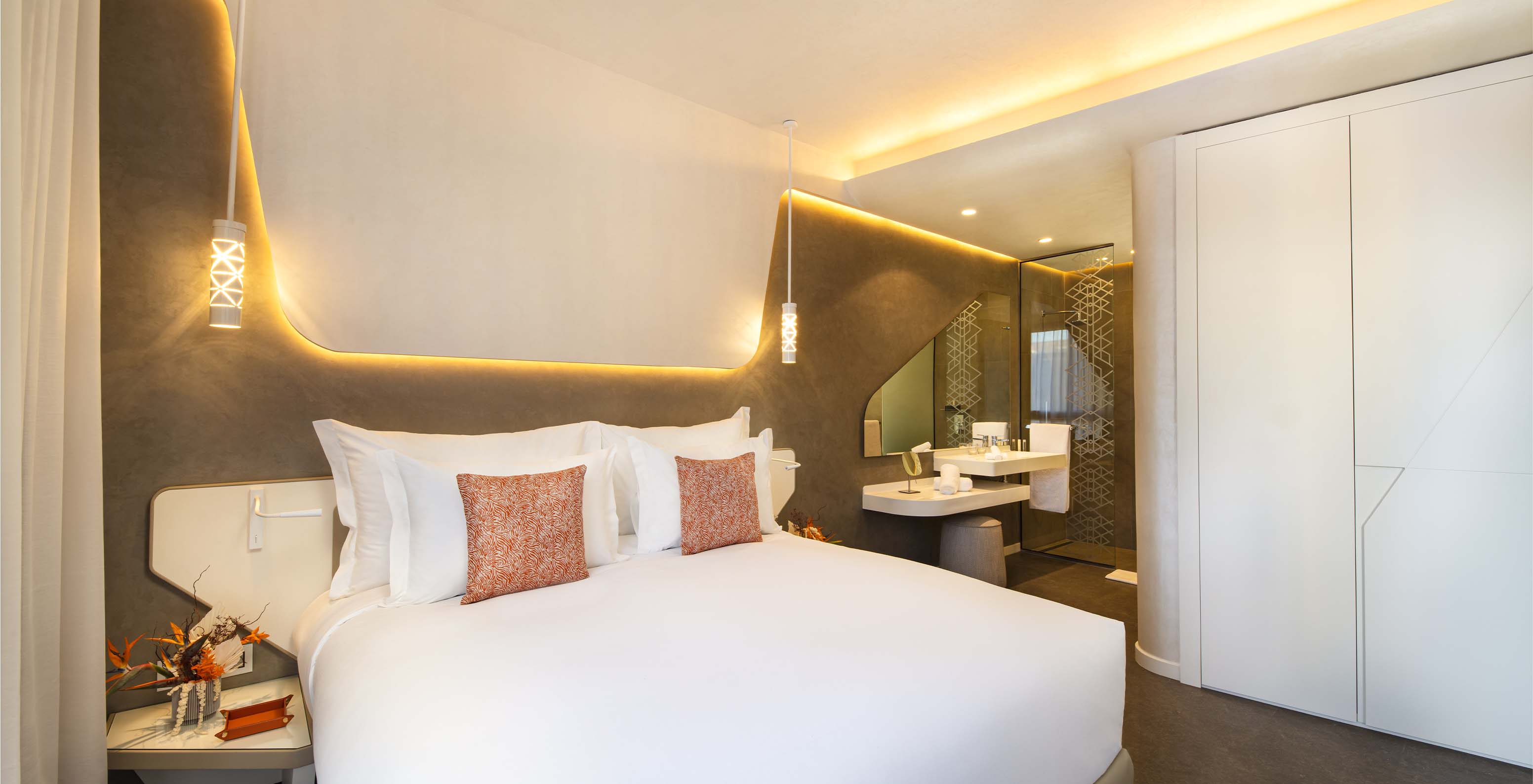 The CR7 Junior Suite at Pestana CR7 Marrakech has a large double bed, wall lights, and a bathroom inside the room