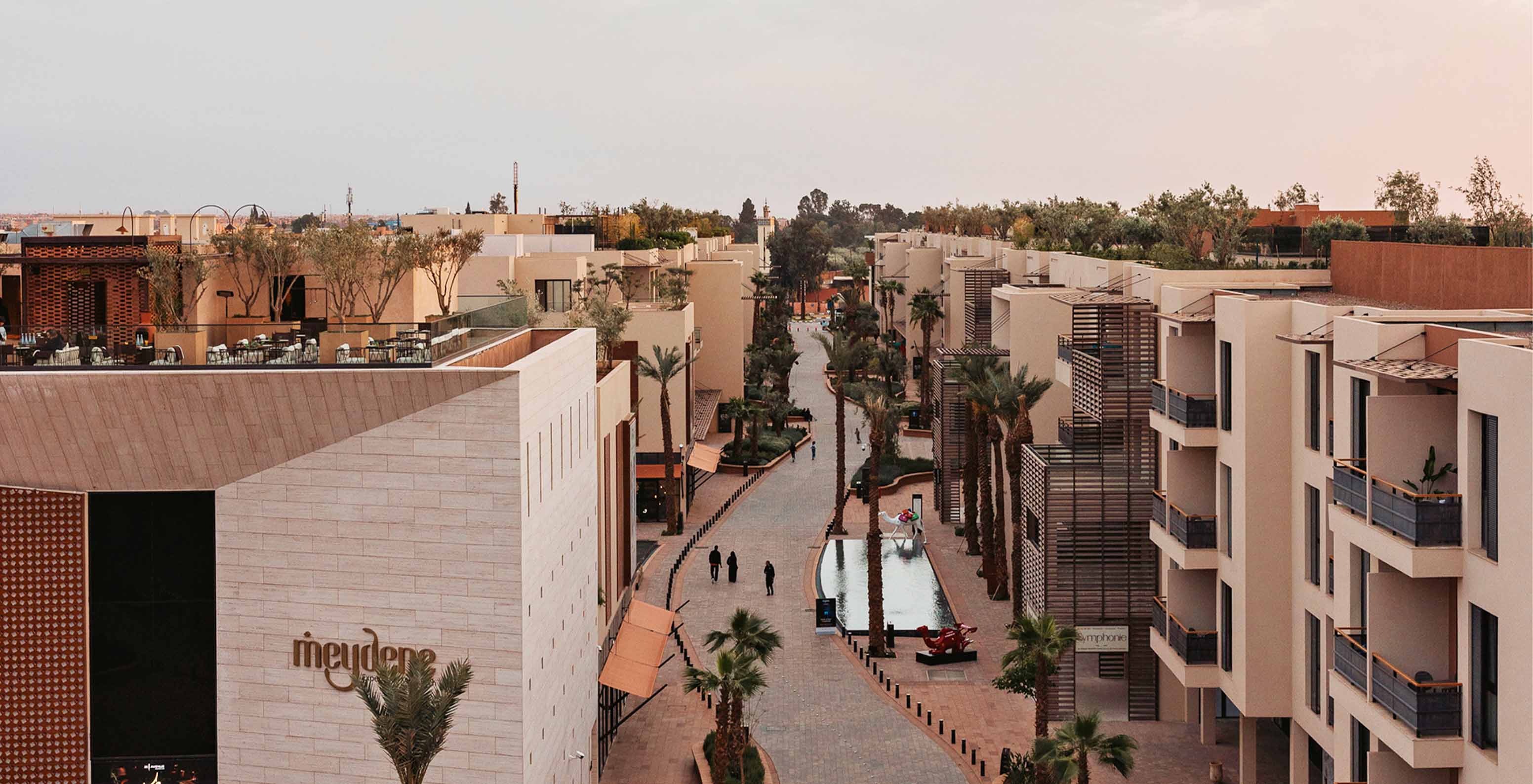 M Avenue, featuring modern facade with traditional arches and mosaics, palm trees creating a chic vibe