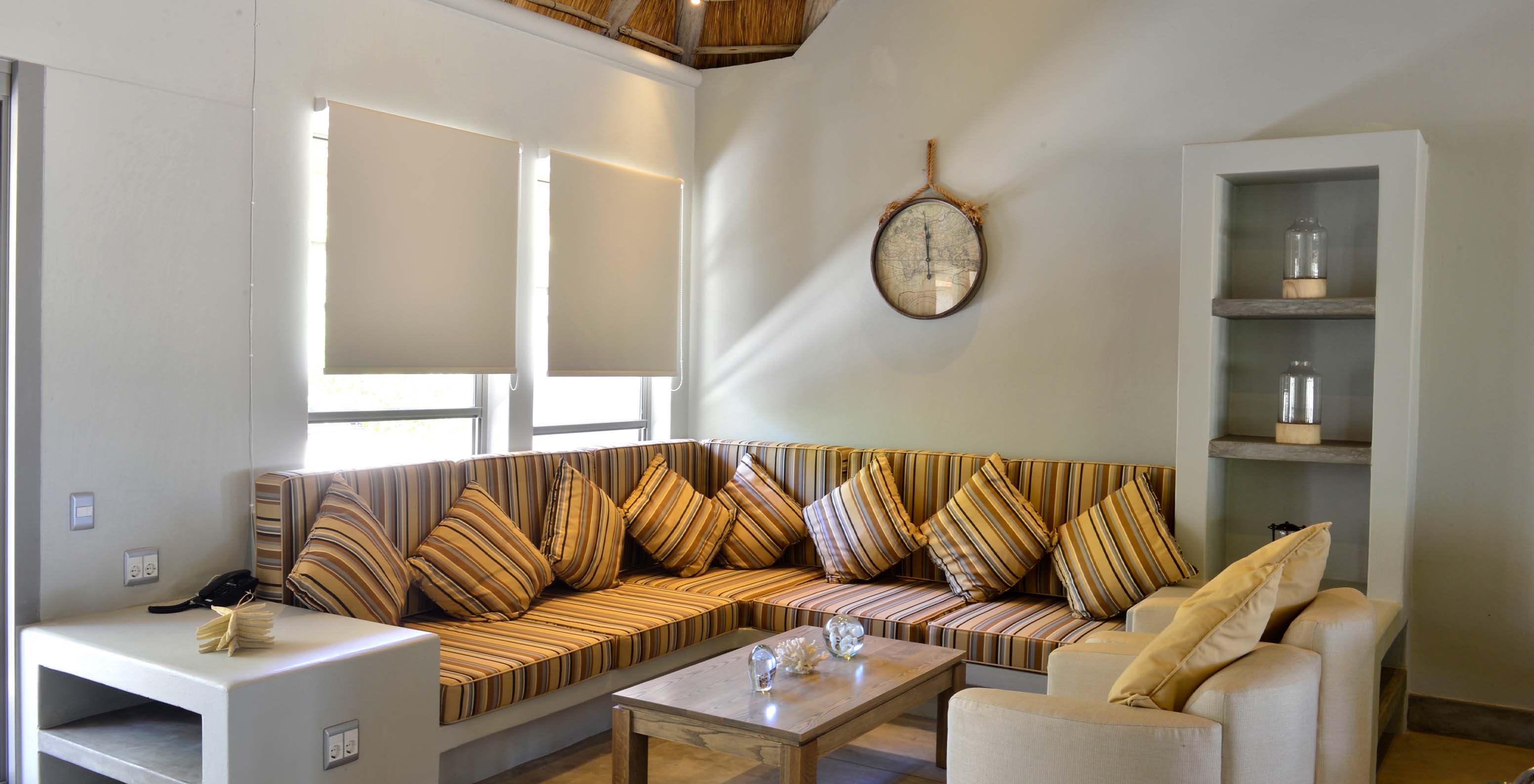 T2 Villas at Pestana Bazaruto Lodge have an L-shaped stone sofa with colorful cushions and two armchairs