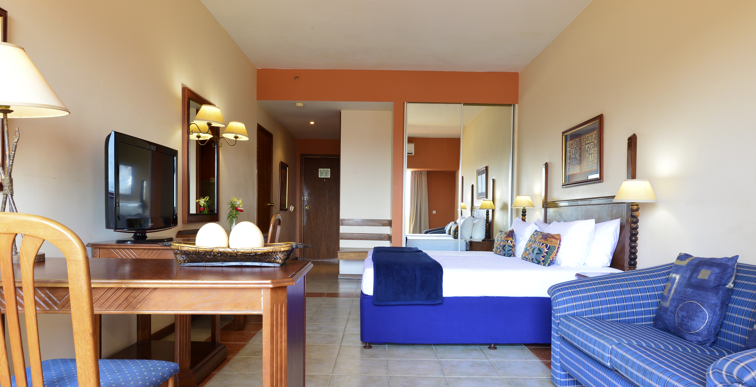 The Family Executive Suite of Pestana Rovuma has a double bed, wardrobe with mirror, television, and a sofa