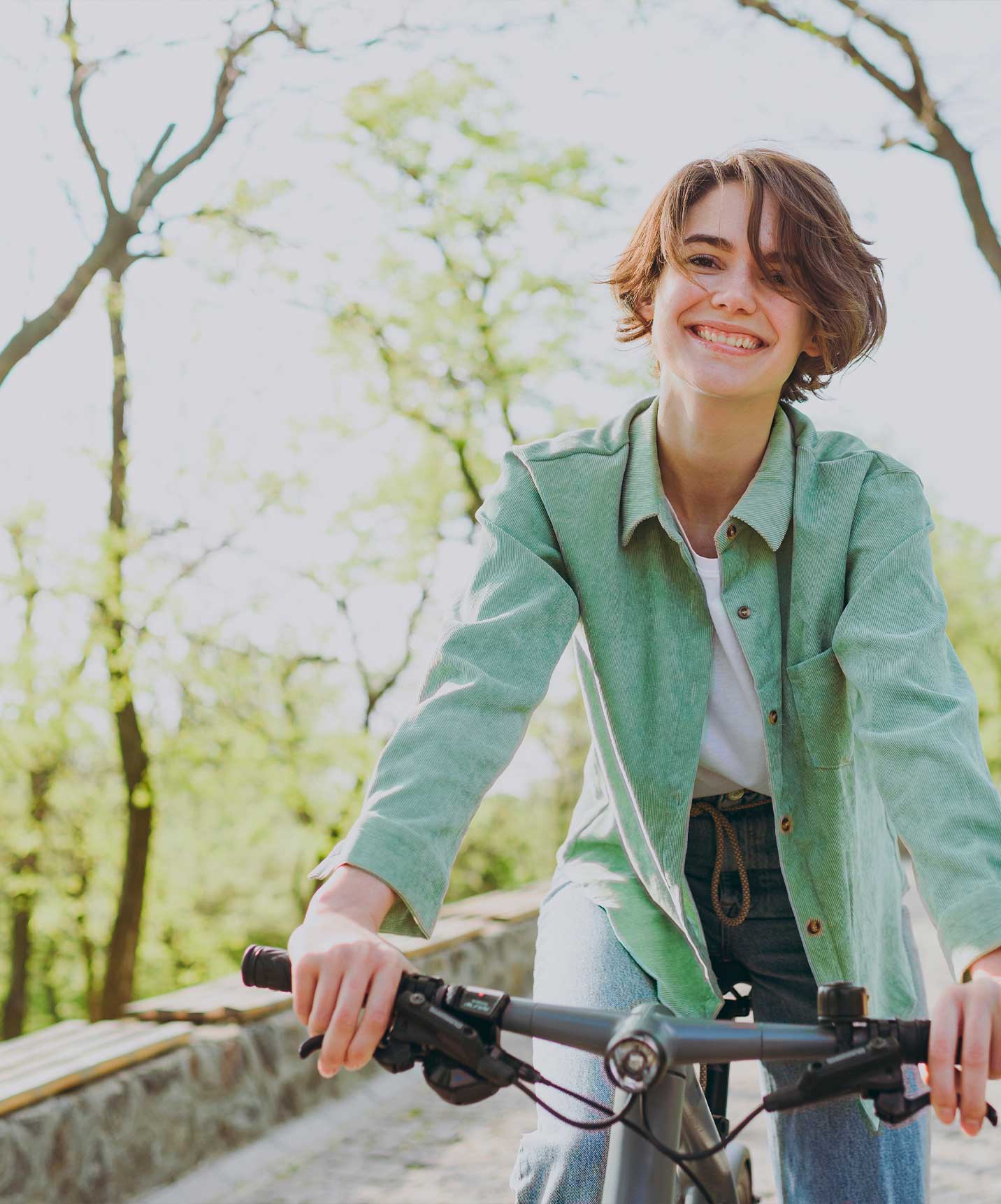 Girl riding a bike at an aparthotel by the sea with a swimming pool