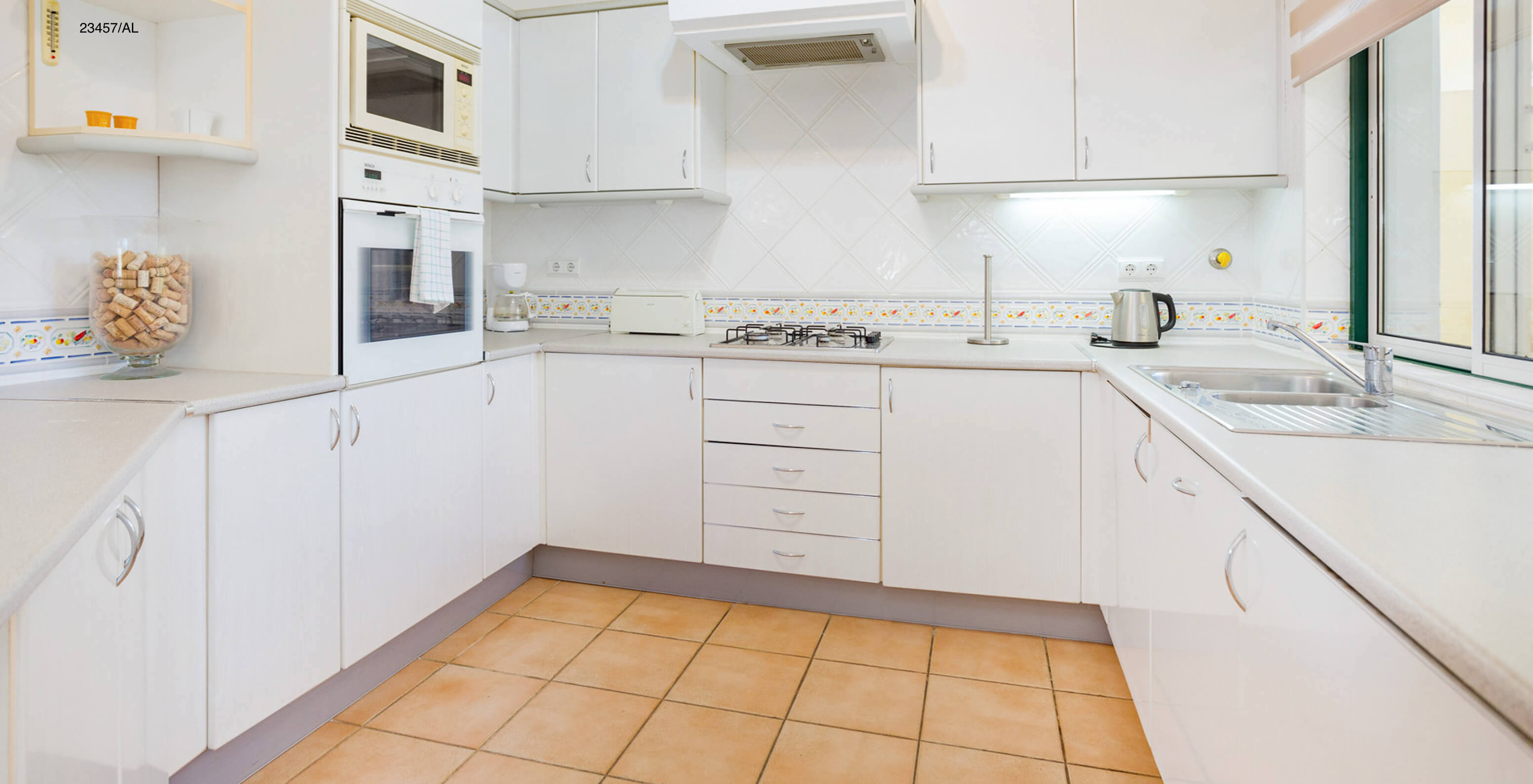 The Pestana Carvoeiro Golf T3 Standard Apartment has a kitchen with white cabinets and a countertop