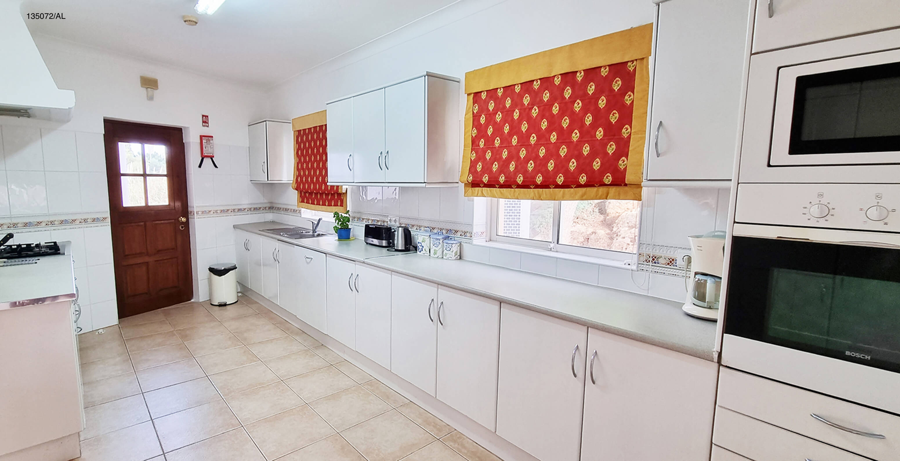 The Pestana Carvoeiro Golf V3 Standard Villa has a kitchen equipped with white cabinets and appliances