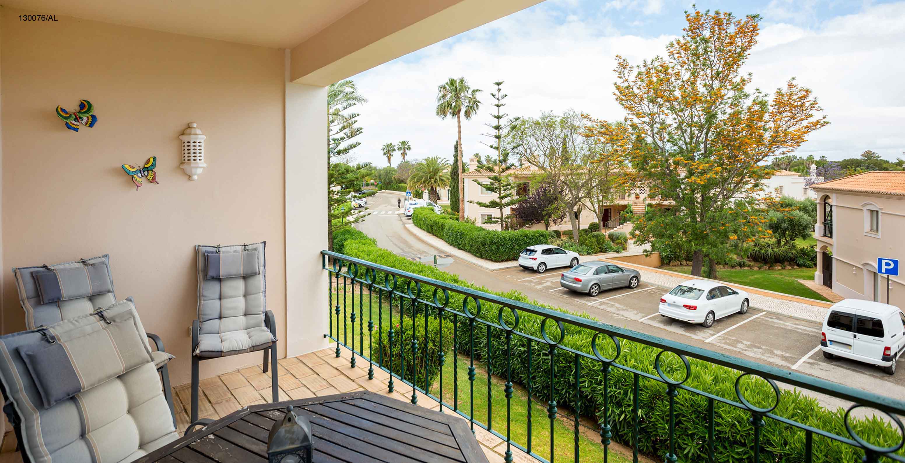 The Pestana Carvoeiro Golf T2 Standard Apartment has a balcony with tables and chairs, with a street view