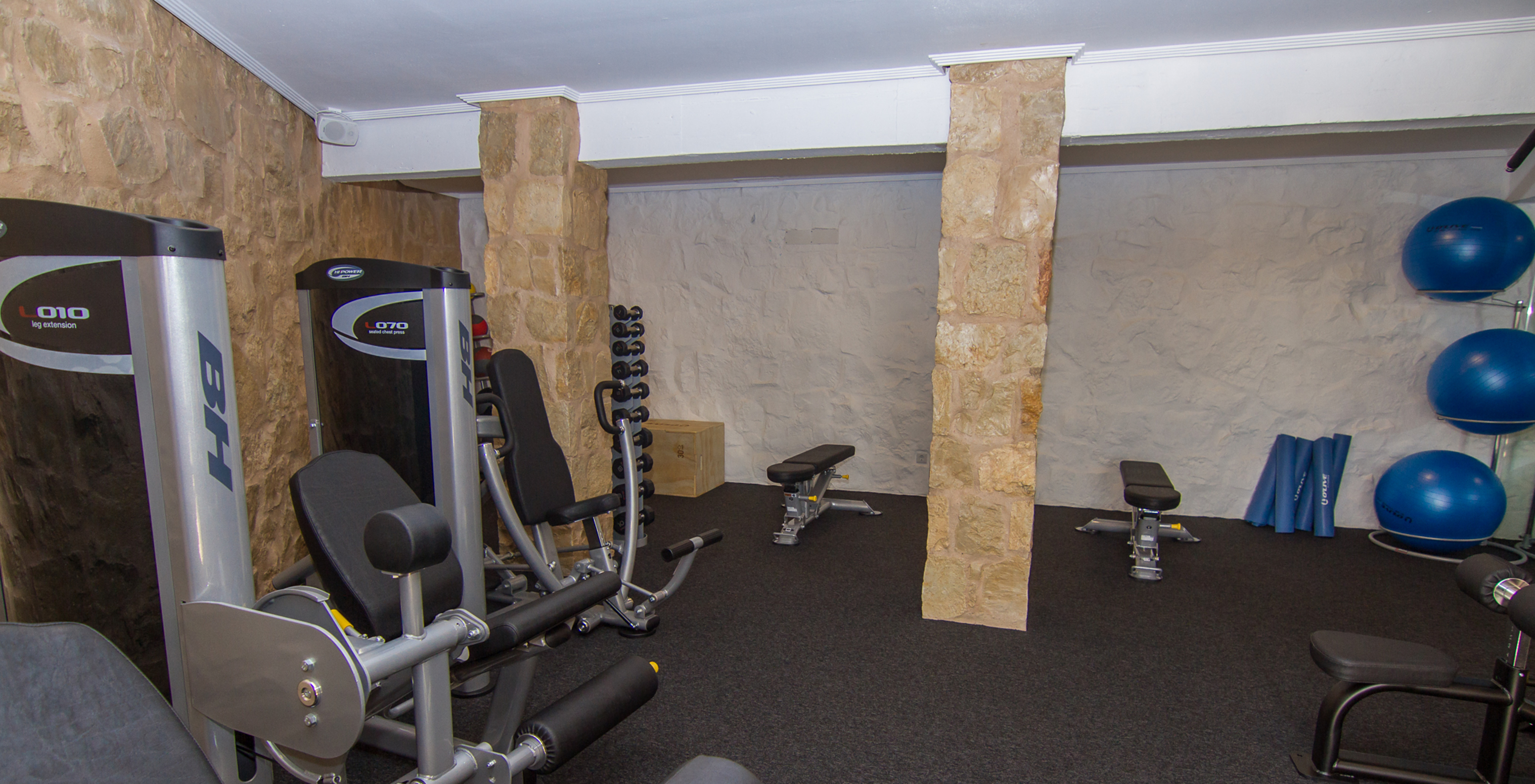 Hotel gym with a pool located on a golf course, equipped with machines and weights for strength training