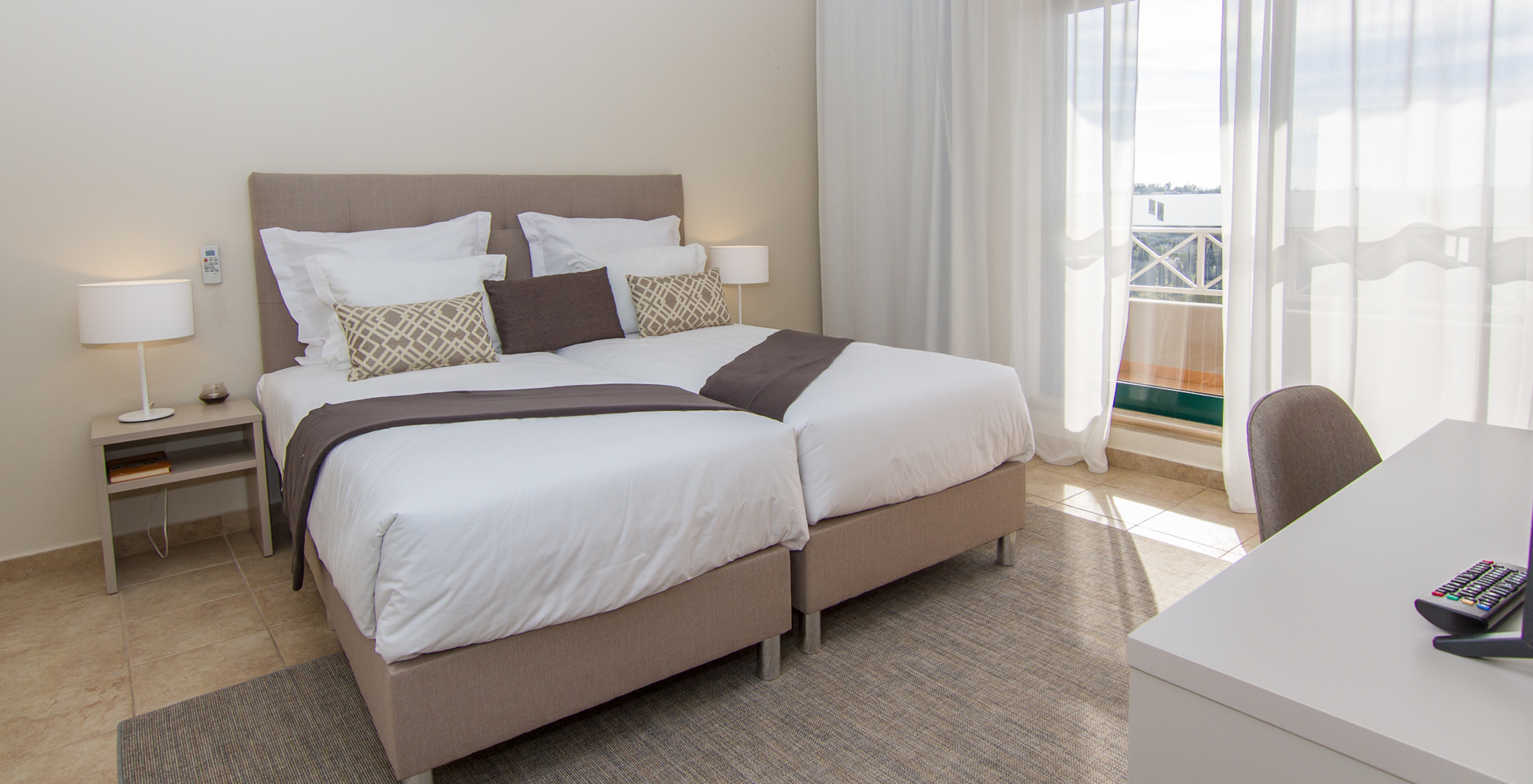 The T2 Apartment at Pestana Gramacho Residences has two single beds, air conditioning, and a window with a balcony