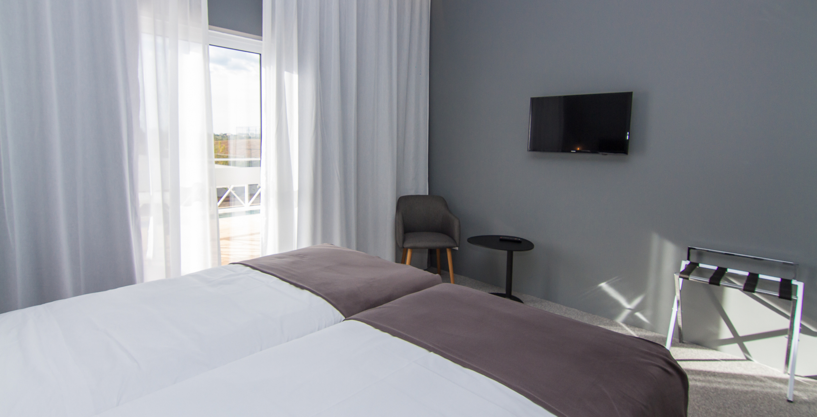 The Classic Pool View room at Pestana Gramacho Residences has two single beds, a television, and a window