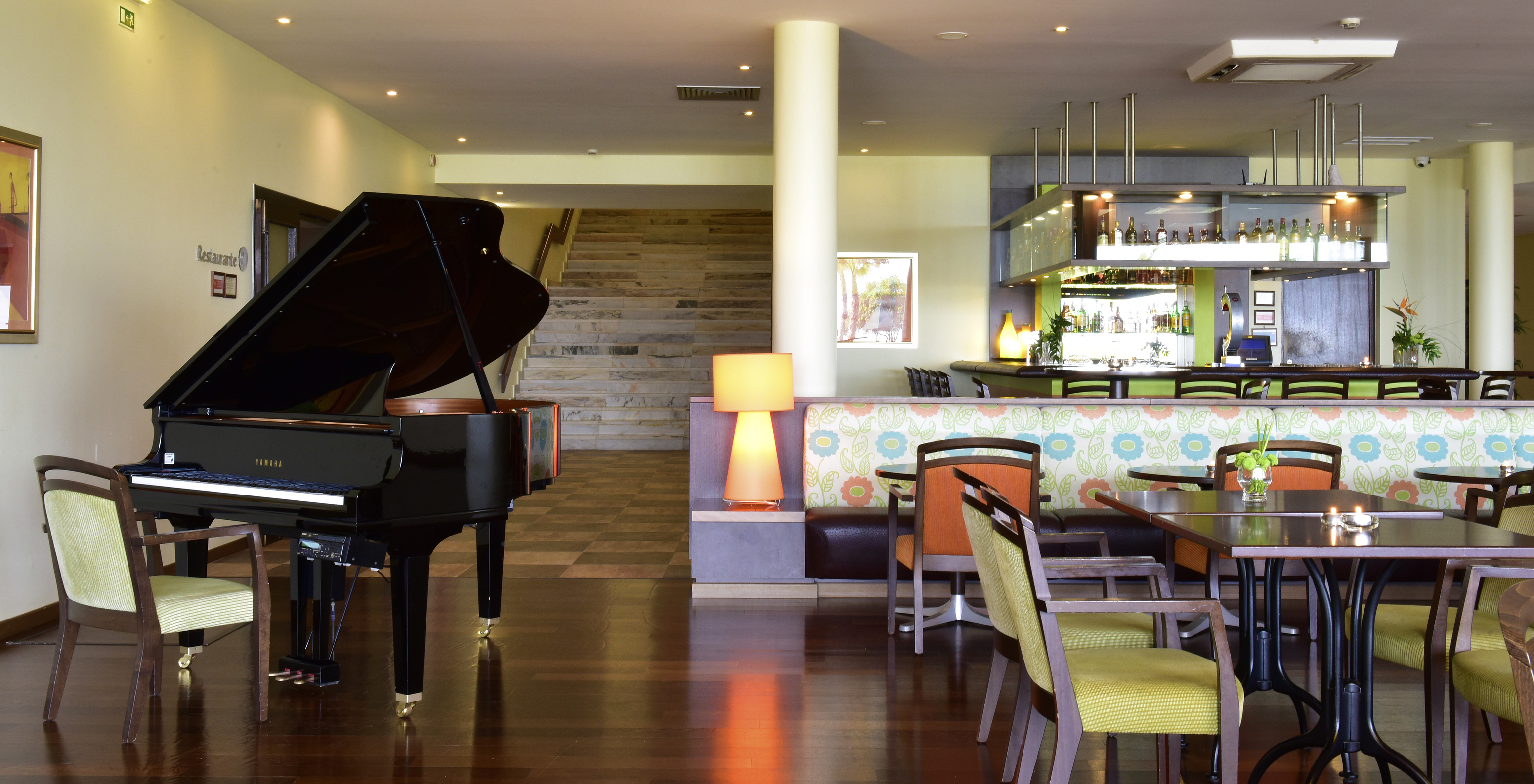 The Tapas Bar at the 4-Star Hotel in Porches features tables and chairs, a piano, and a bar for drinks