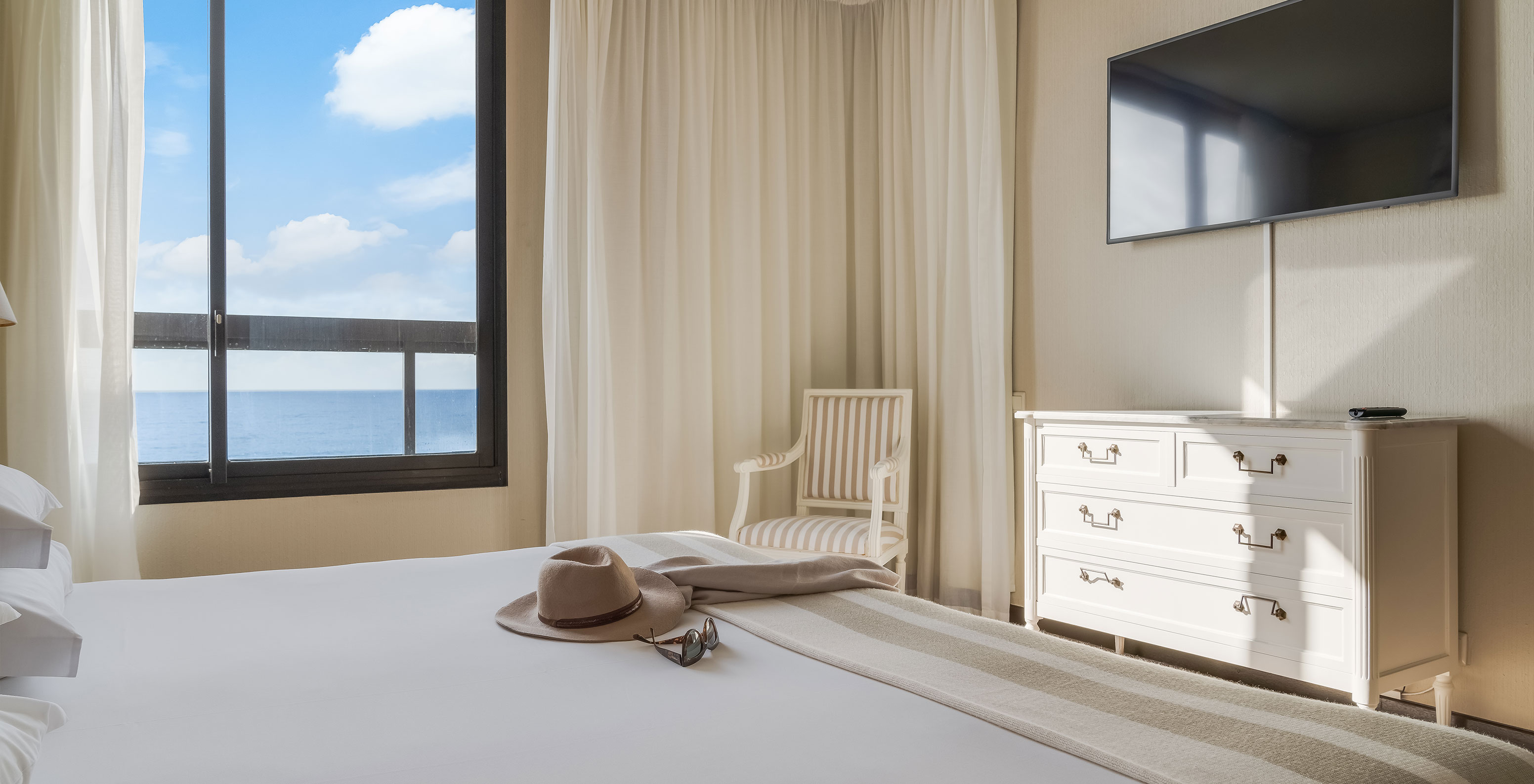 Suite at Pestana Bahia Praia has a double bed, with a window on the left and a TV at the foot of the bed