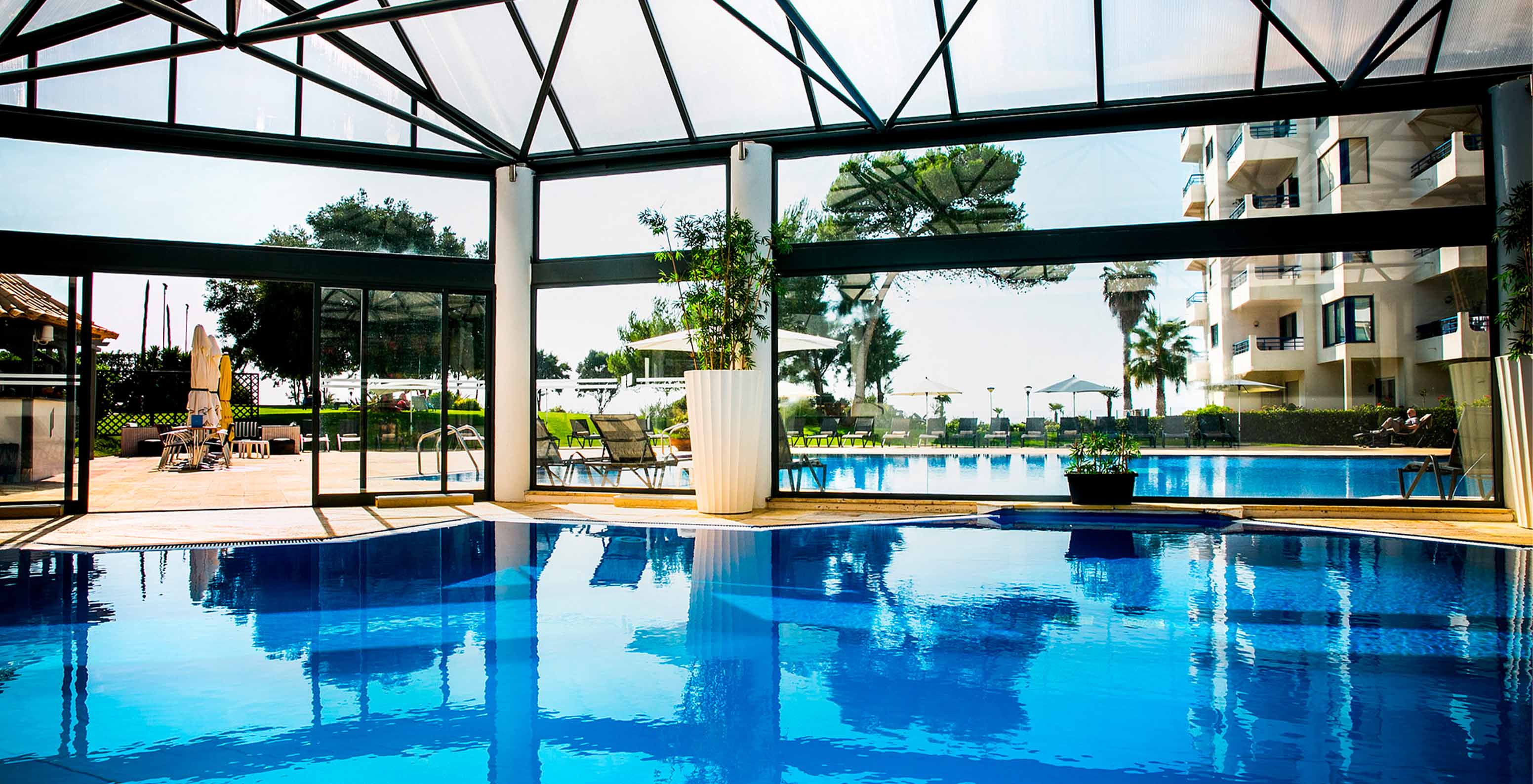 Pestana Cascais, hotel facing the sea with spa, features a heated indoor pool overlooking the outdoor pool