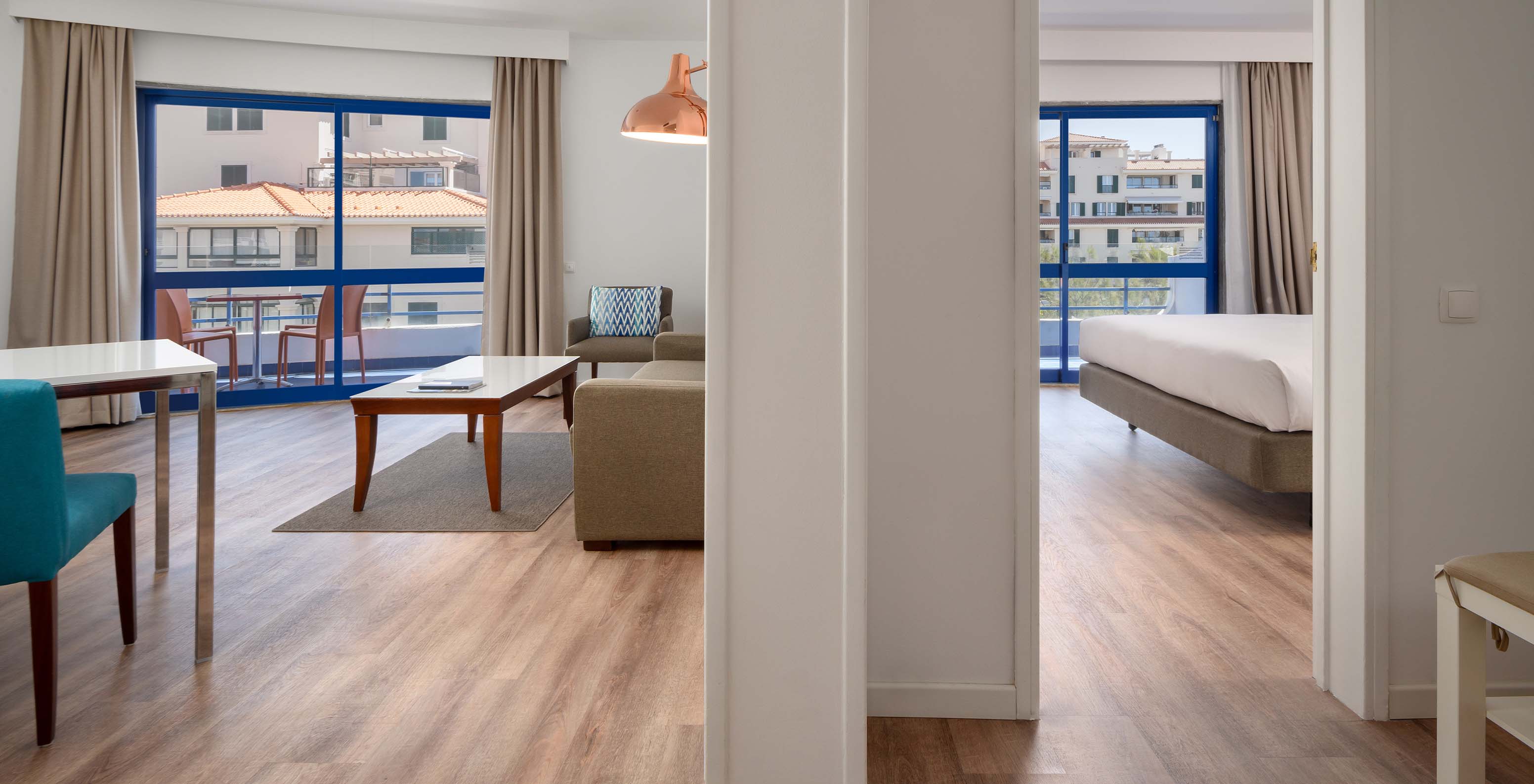 The Deluxe Sea View Suite at Pestana Cascais has a living room with a sofa, coffee table, and balcony