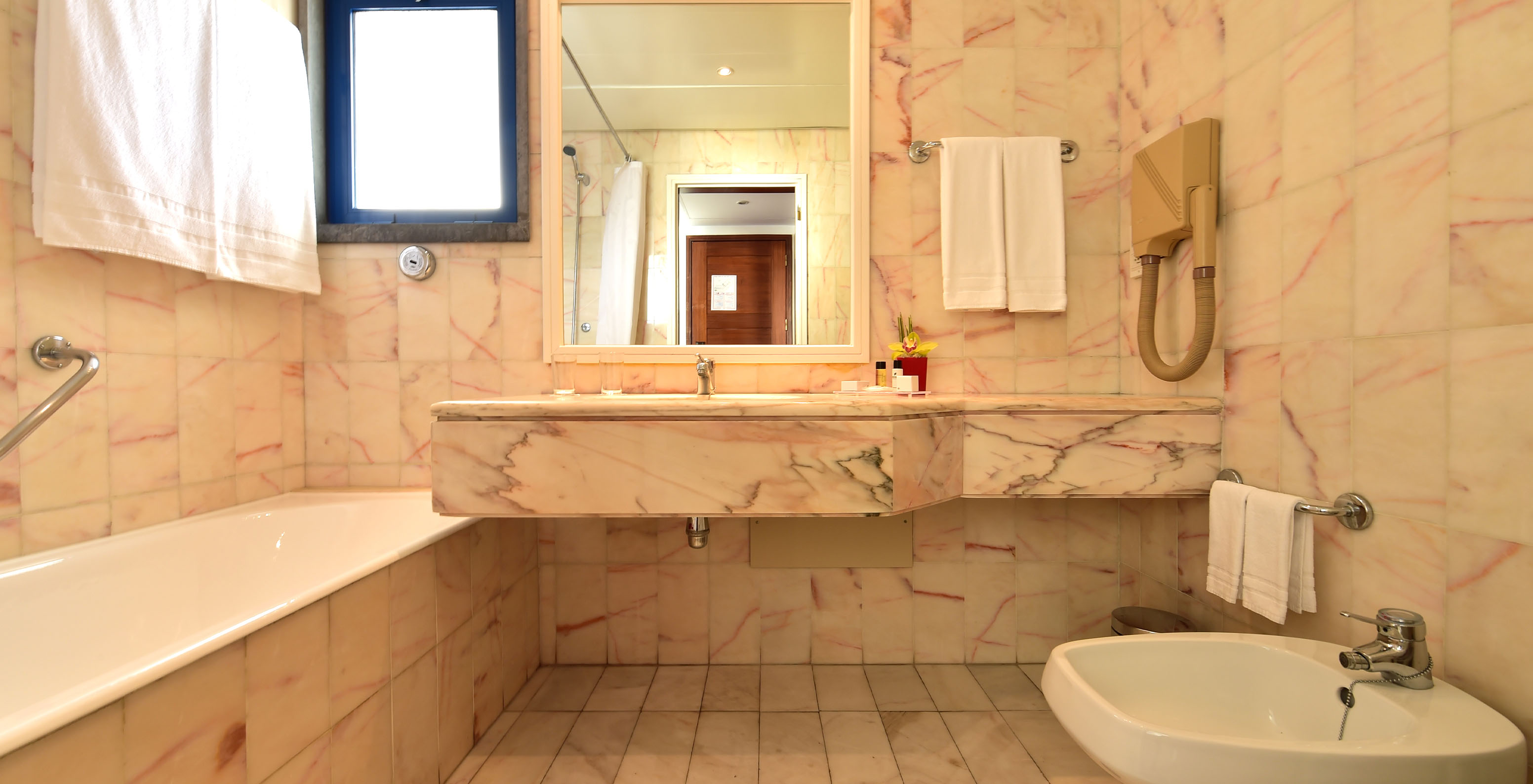 The Deluxe room at Pestana Cascais has a bathroom with a mirror, sink, and bathtub