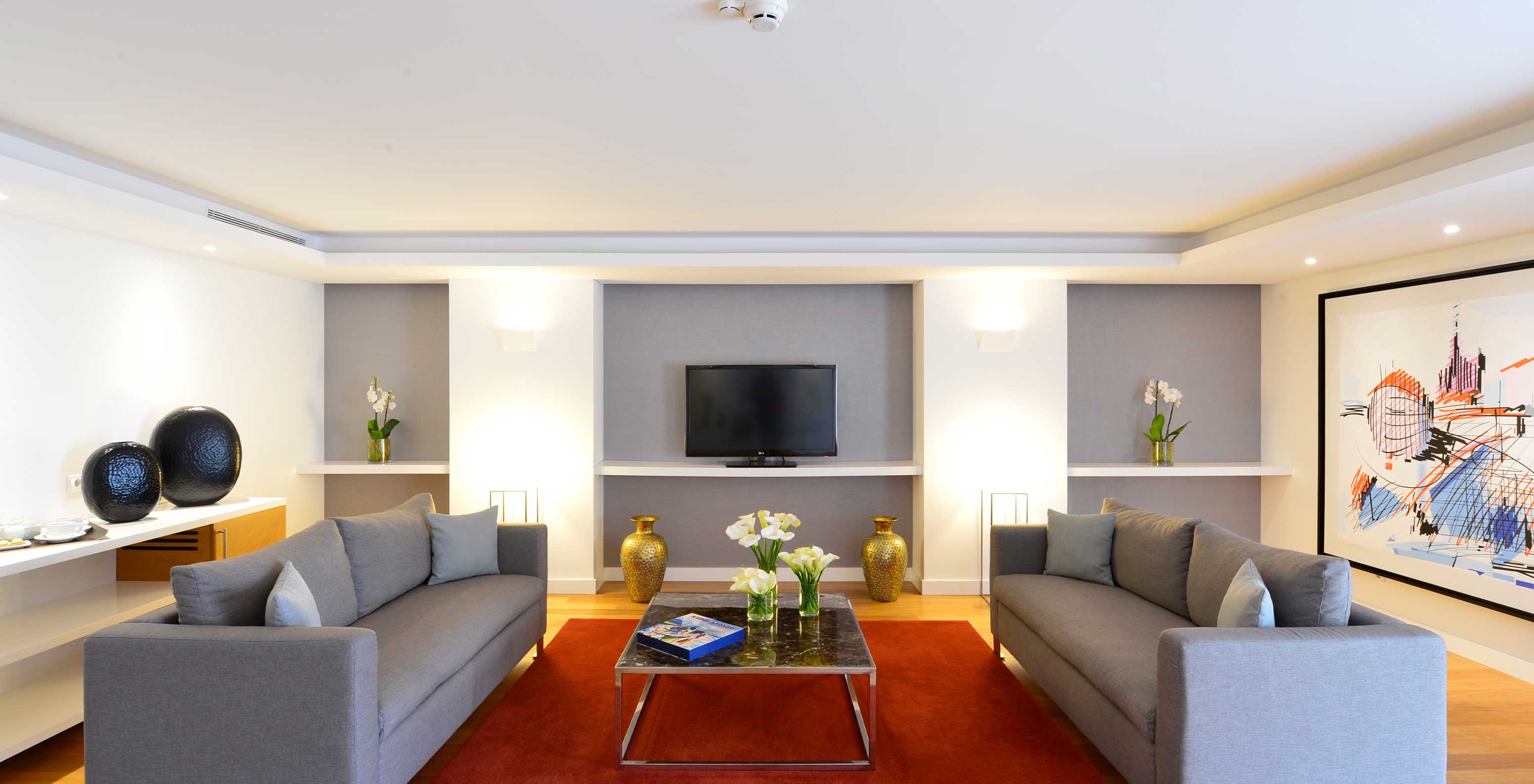 The Presidential Suite at Pestana Cidadela Cascais has a living room with two large sofas, a coffee table, and a TV