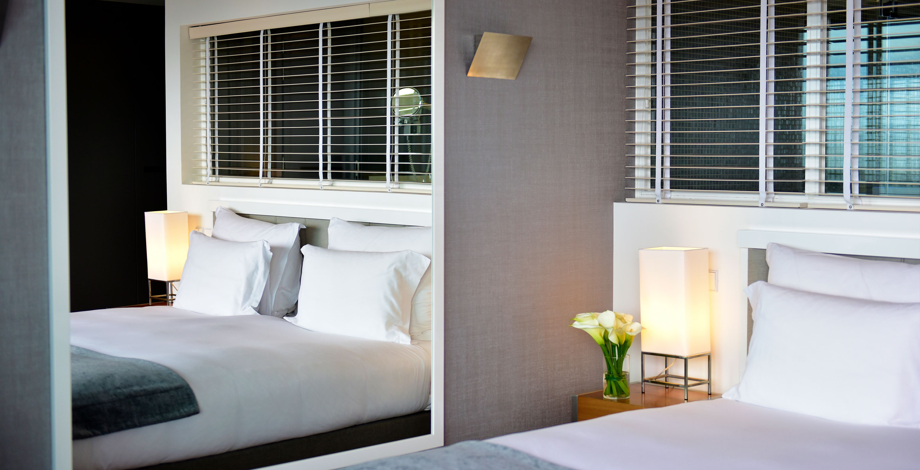 The Sea View Suite at Pestana Cidadela Cascais has a double bed, a bedside table, and a large mirror