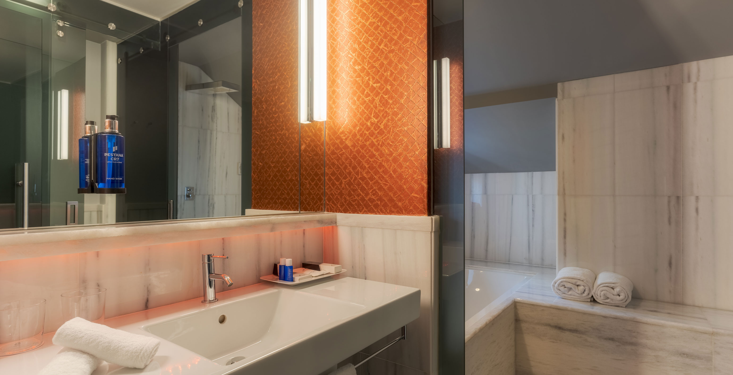 The CR7 Suite at Pestana CR7 Lisboa includes a bathroom with mirror, sink, and bathtub with shower