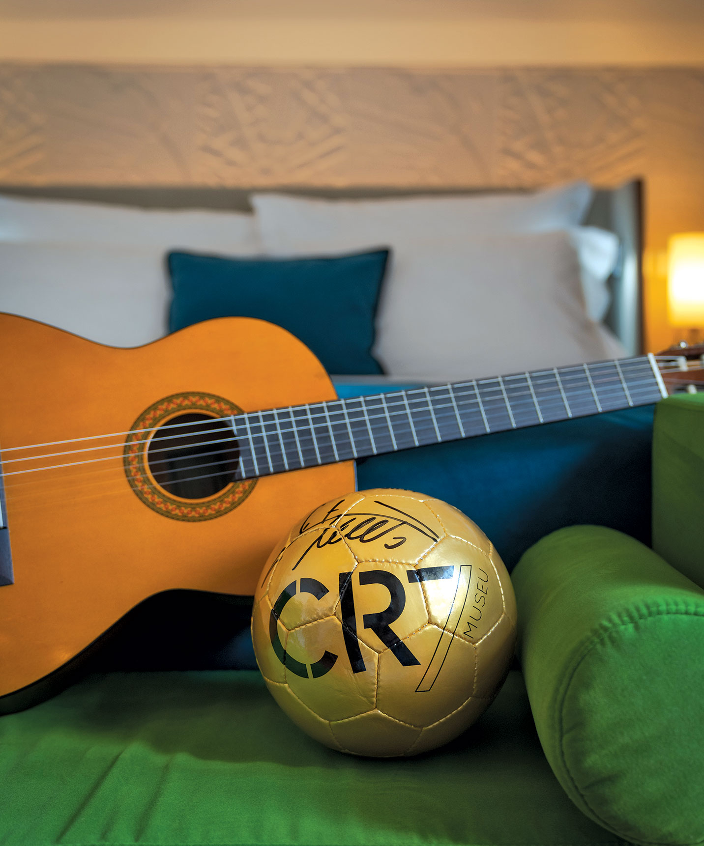 Sofa with a golden ball autographed by Cristiano Ronaldo and a guitar