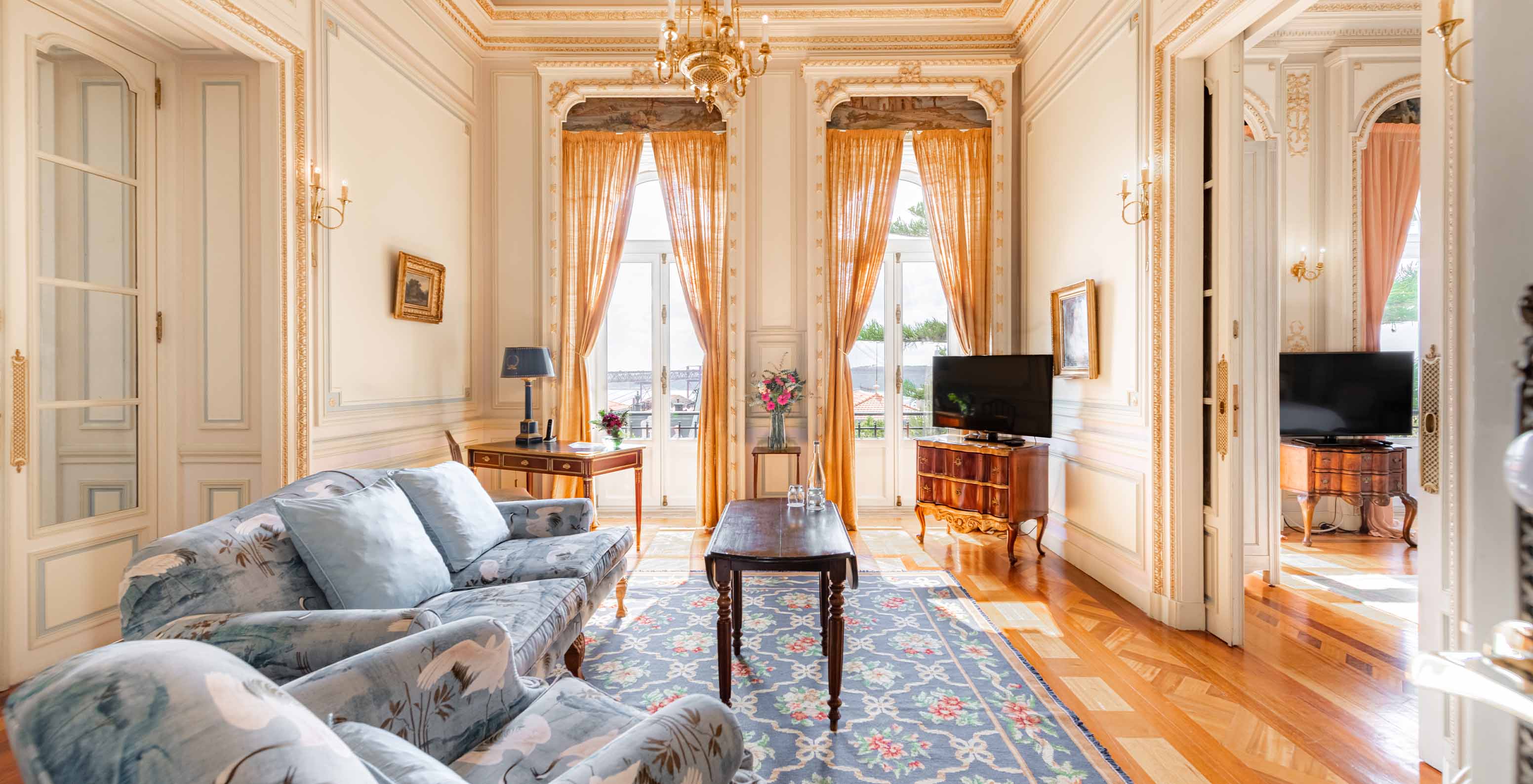 The Suite D. Manuel/D. Luís Filipe do Pestana Palace Lisboa has a luxurious living room with a sofa, TV, window and rug